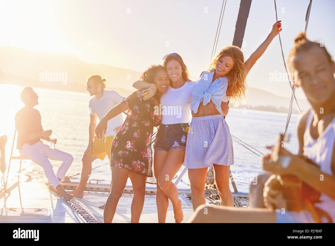 Verspielte Frauen Freunde tanzen auf sonnigen Katamaran Stockfoto