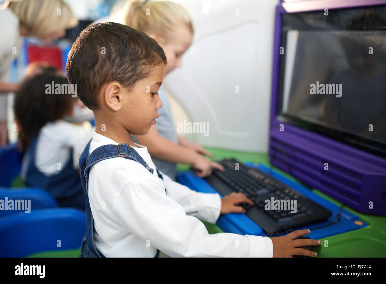 Neugierige Junge mit Computer Stockfoto