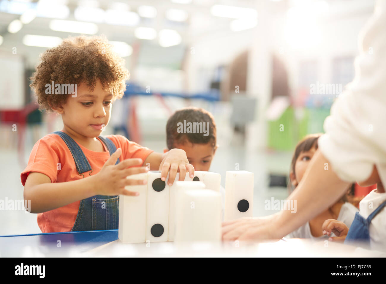 Neugierige Kinder spielen mit großen dominos in Science Center Stockfoto