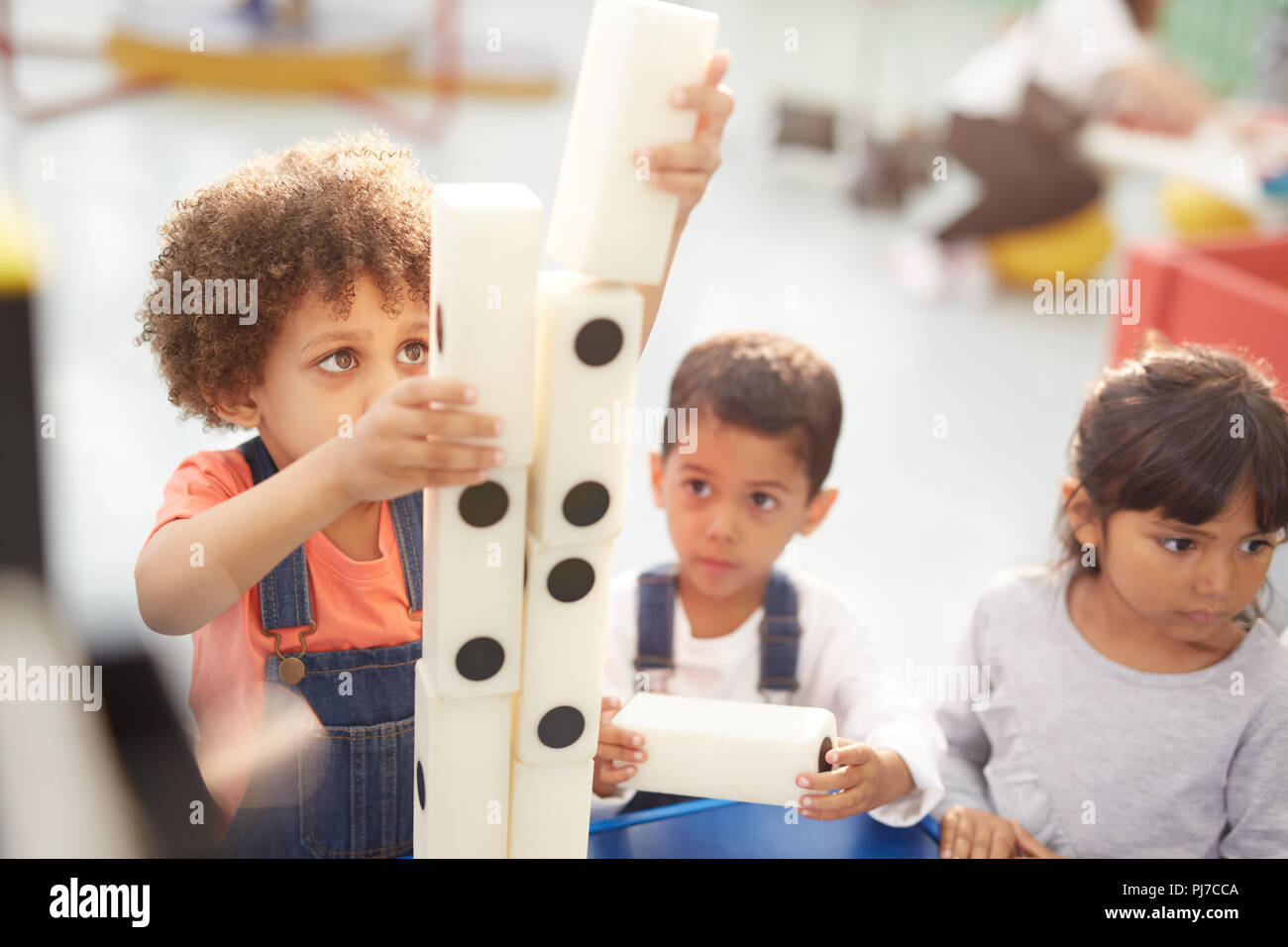 Neugierige Kids stapeln große Dominos auf der interaktiven Ausstellung in Science Center Stockfoto