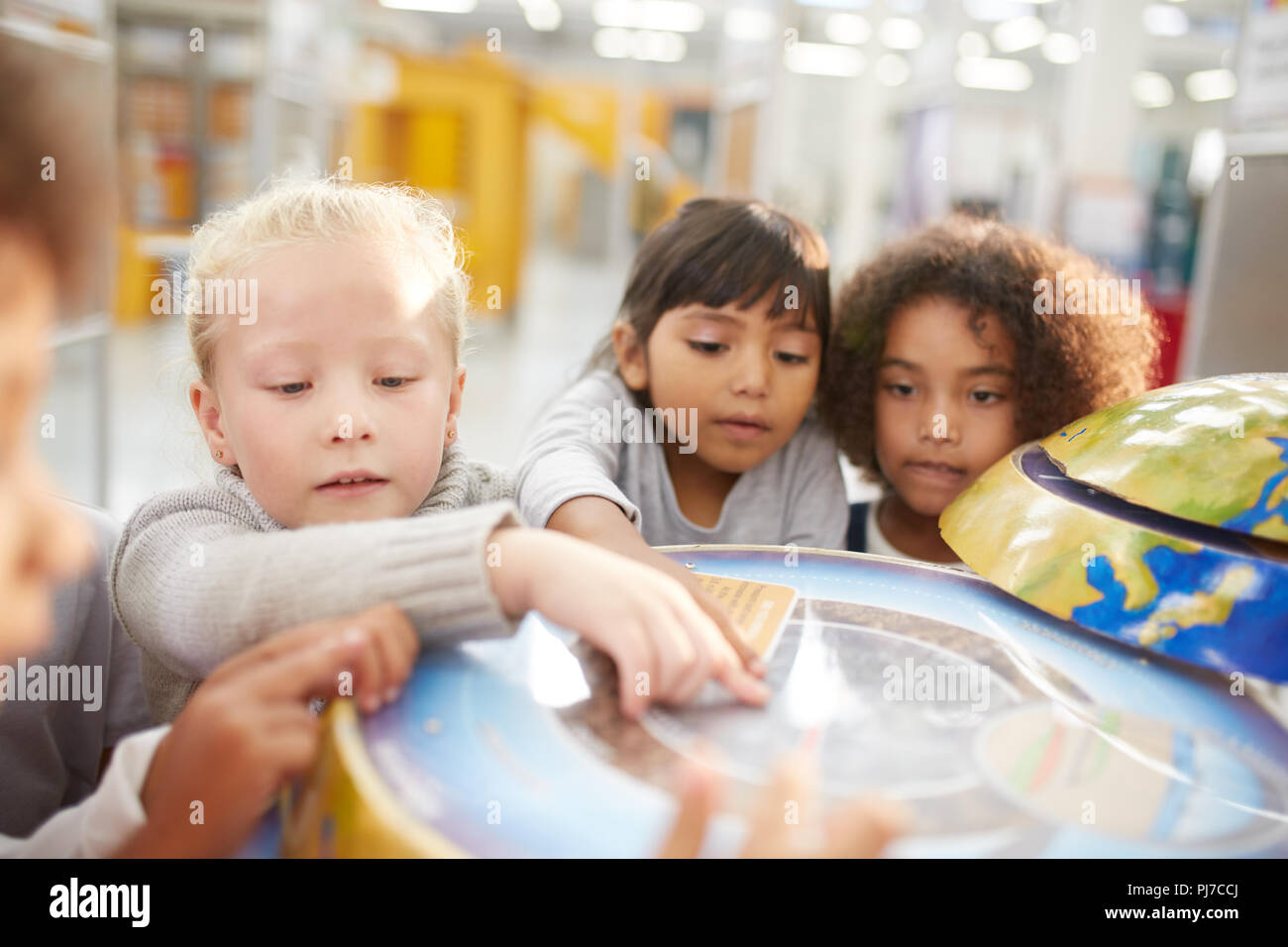 Neugierige Kinder in interaktiven Globus weisen im Science Center Stockfoto