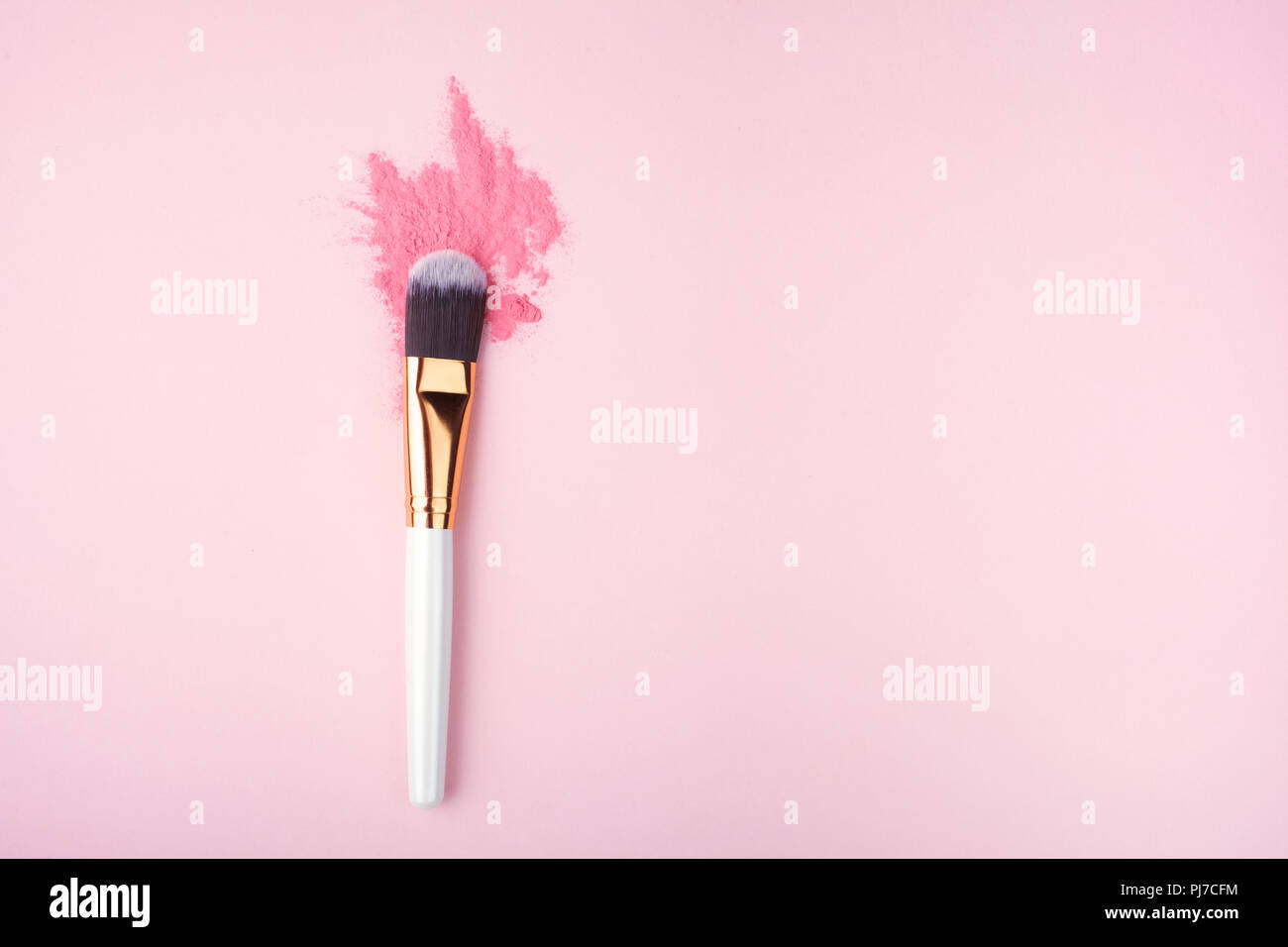 Make-up-Pinsel auf rosa Hintergrund mit bunten Farbpulver Stockfoto