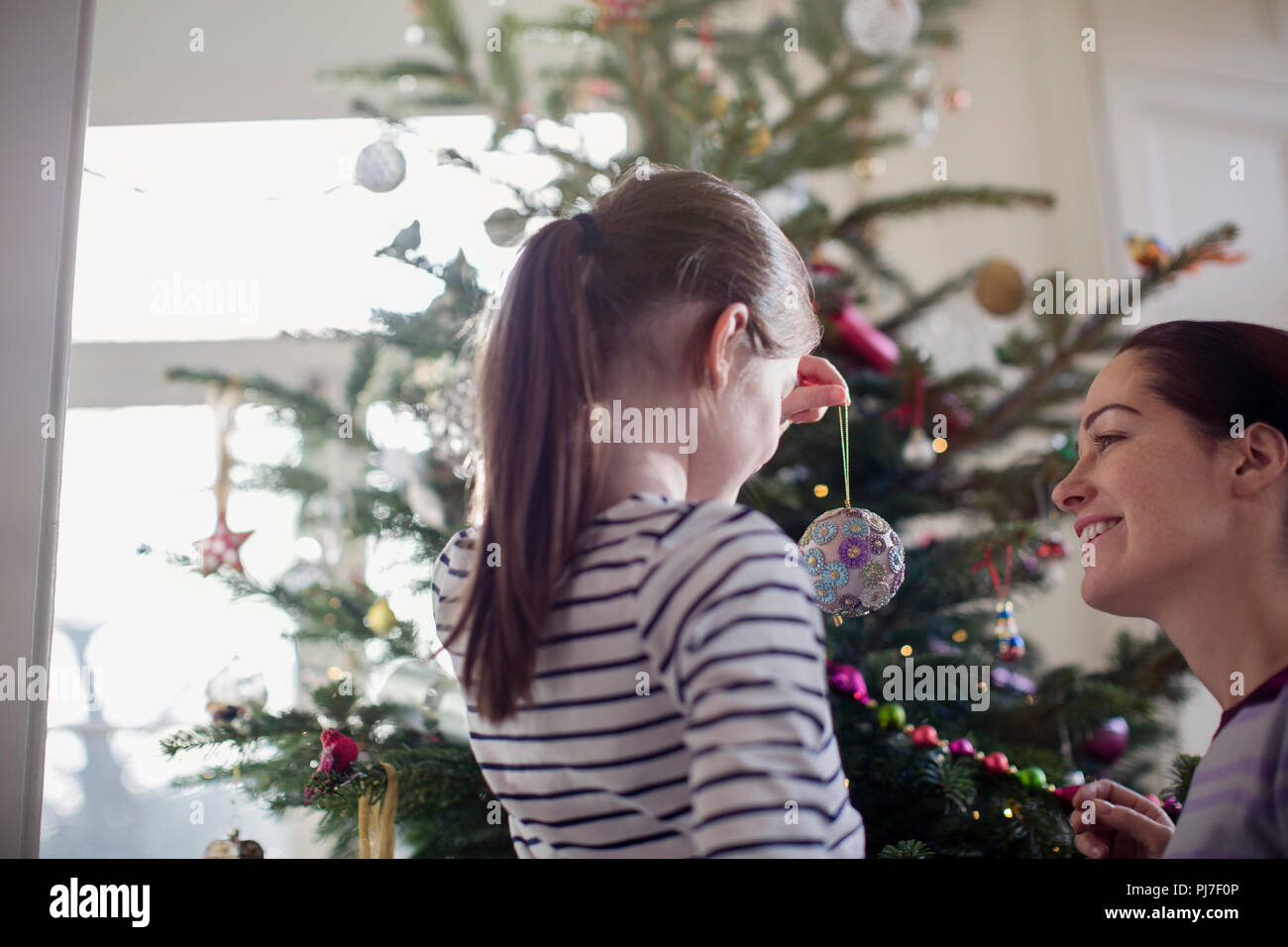 Mutter und Tochter schmücken Weihnachtsbaum Stockfoto
