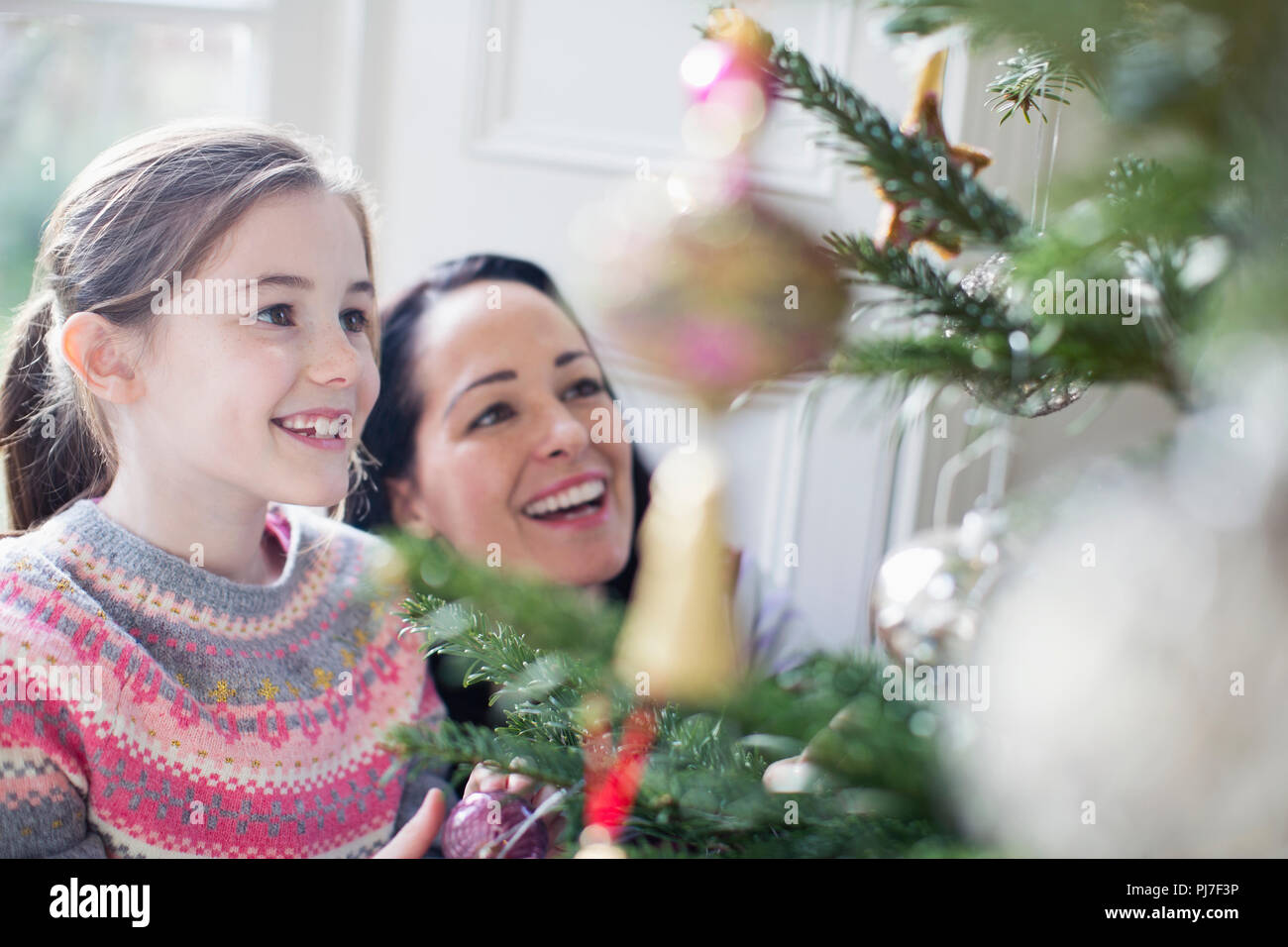 Glückliche Mutter und Tochter schmücken Weihnachtsbaum Stockfoto