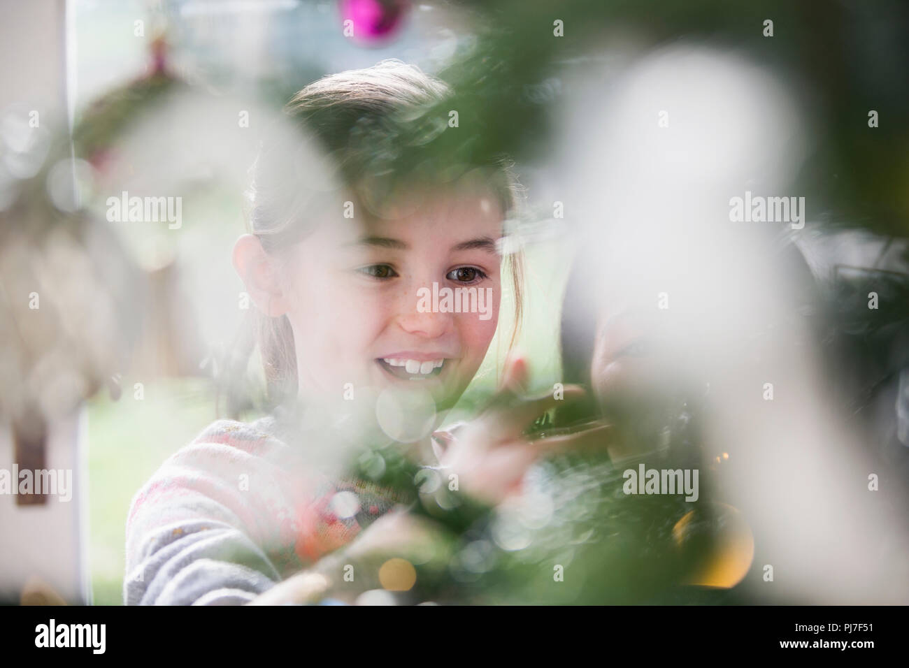 Lächelndes Mädchen schmücken Weihnachtsbaum Stockfoto