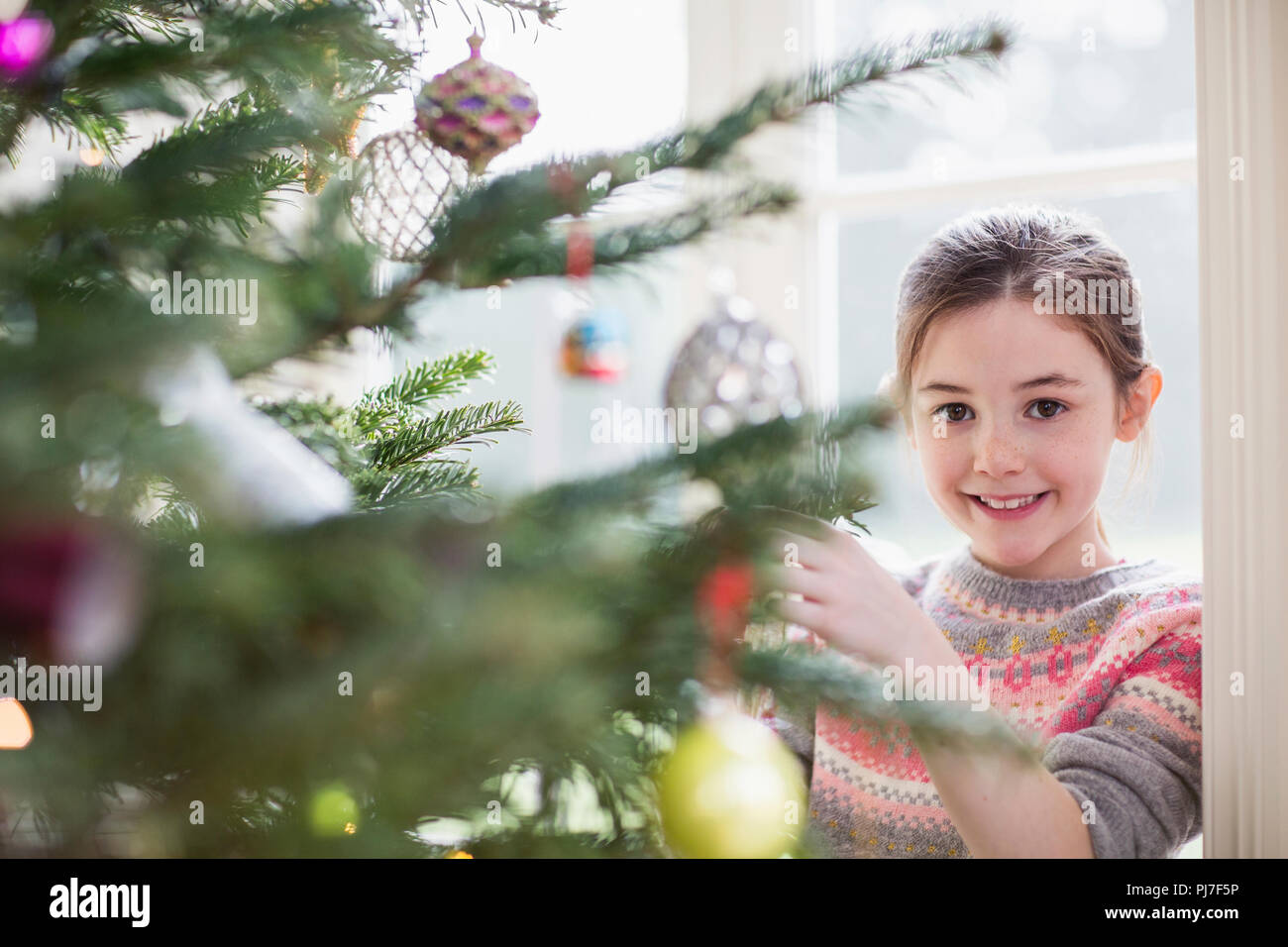 Portrait lächelnde Mädchen schmücken Weihnachtsbaum Stockfoto