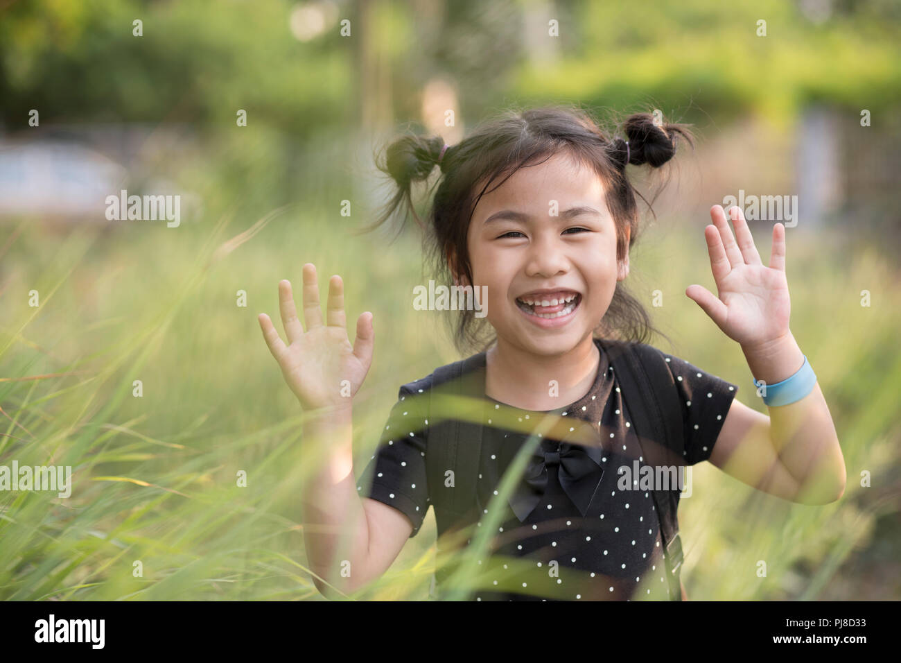 Freundliche asiatische Kinder Witze spielen im grünen Gras Feld Stockfoto