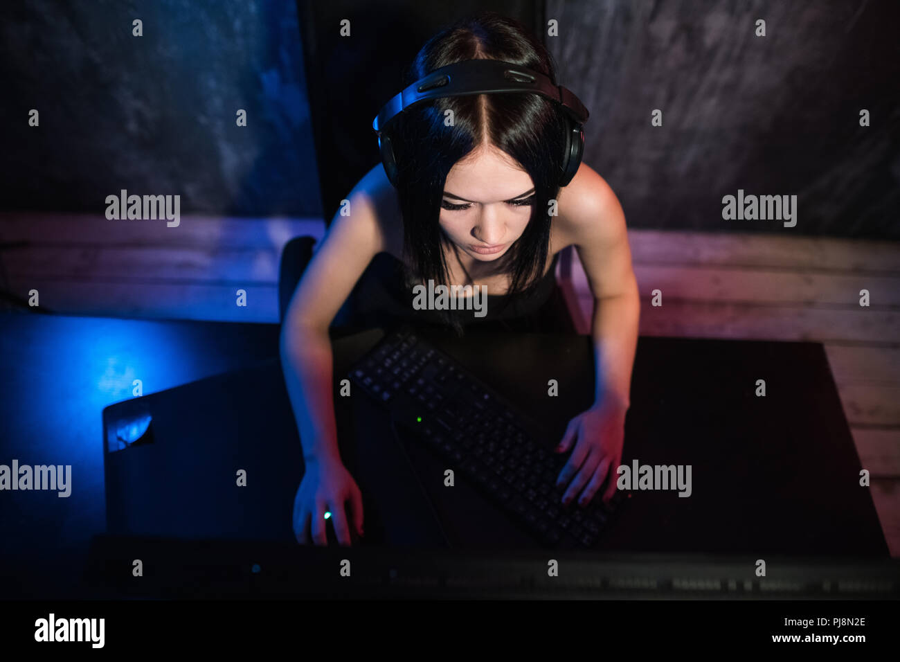 Neue Ebene. Ansicht von oben zuversichtlich starken weiblichen Spieler sitzt vor einem PC-Bildschirm beim Durchführen der Ebene und setzt die Hände auf Tastatur und Maus Stockfoto