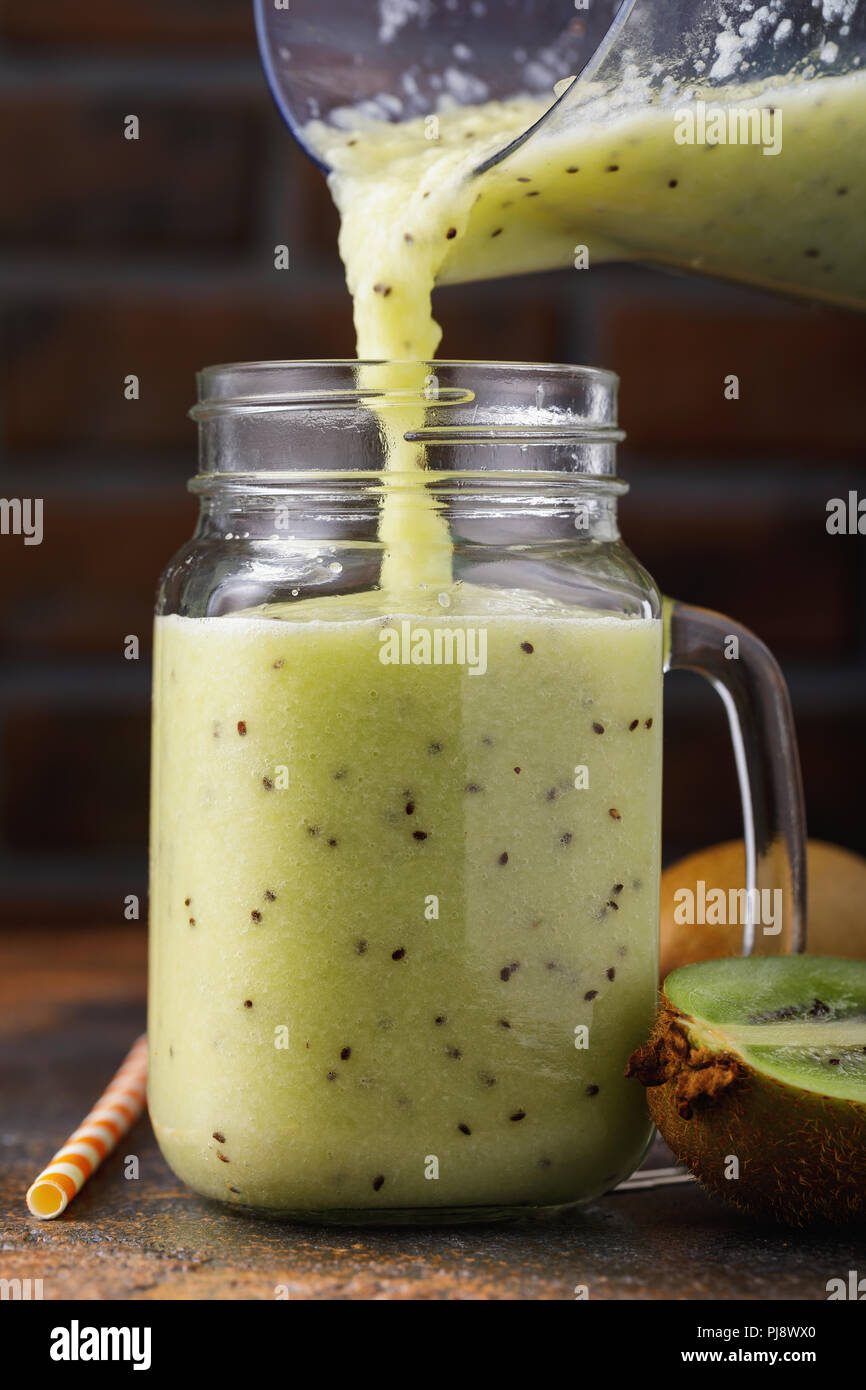 Prozess der Gießen frisch zubereitete Smoothies von Kiwi in einem Glas Stockfoto