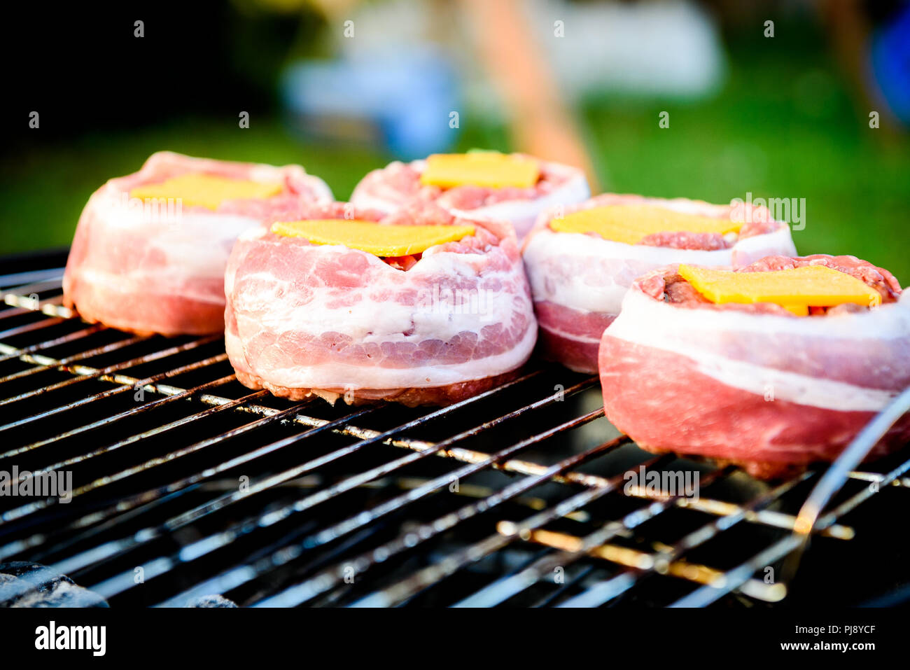Die hausgemachte Bier kann Bacon Burger am Grill zubereitet. Vorbereitung gefüllte Pastetchen, in Speck umwickelt und Grillen auf indirekte Hitze in der Natur an der Bac Stockfoto