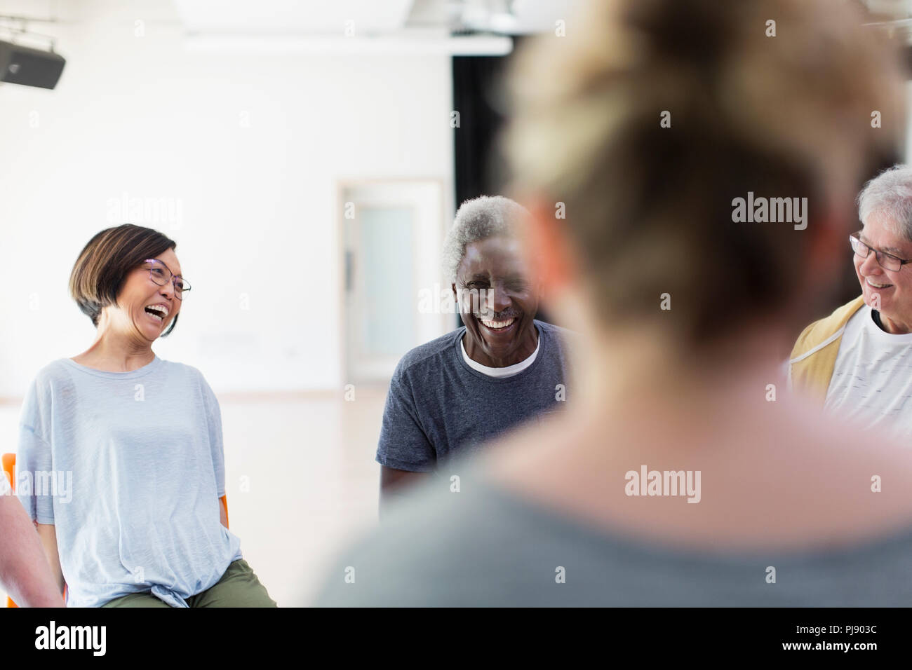 Lachend aktive Senioren im Gespräch in Community Center Stockfoto