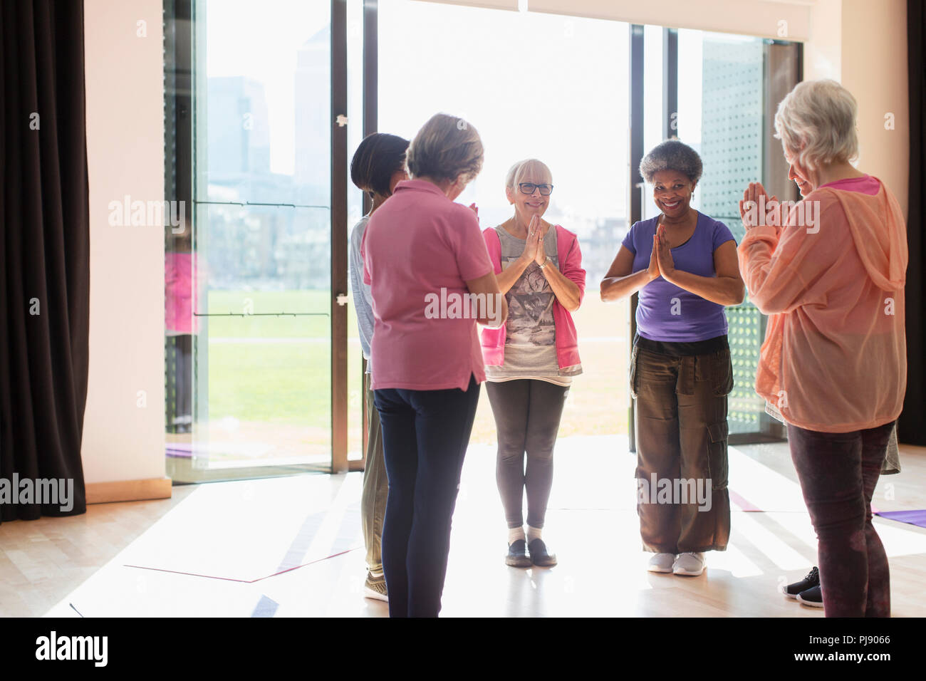 Lächelnd älterer Frauen trainieren, das Praktizieren von Yoga in sonniges Studio Stockfoto
