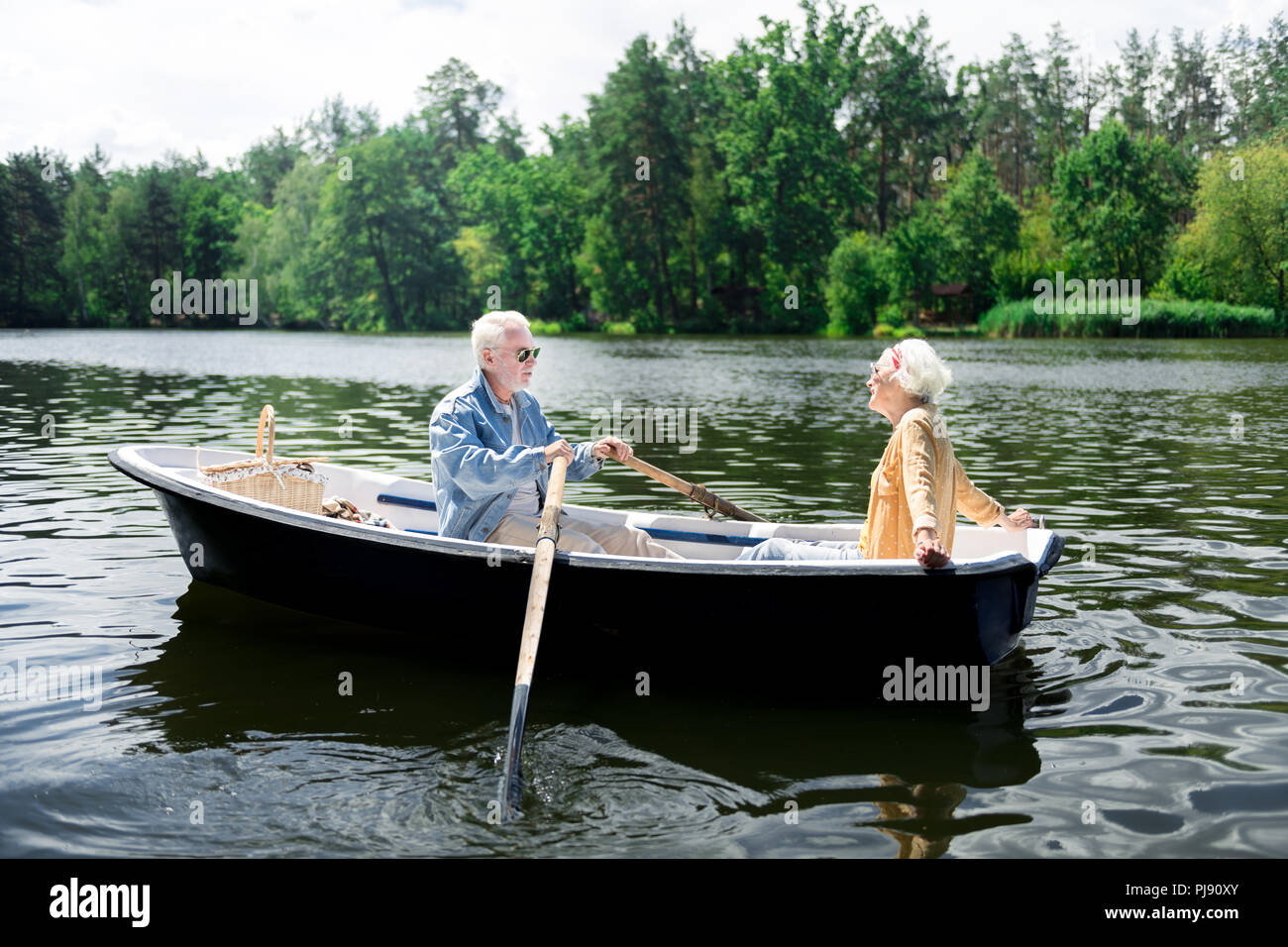 Stilvolle ansprechende ältere Frau Gefühl erstaunliche im Boot mit Ehemann sitzen Stockfoto