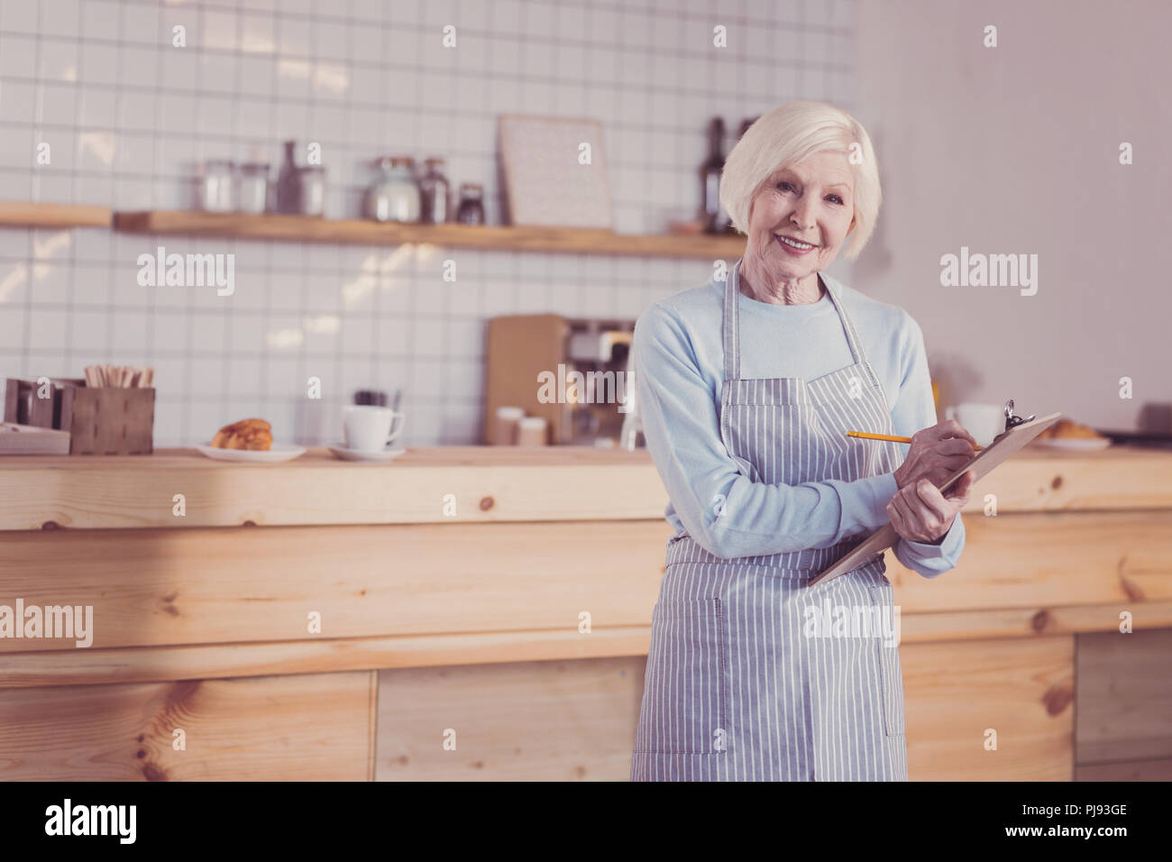 Angenehme verantwortlich Frau stehen und Schreiben auf der Tablette. Stockfoto