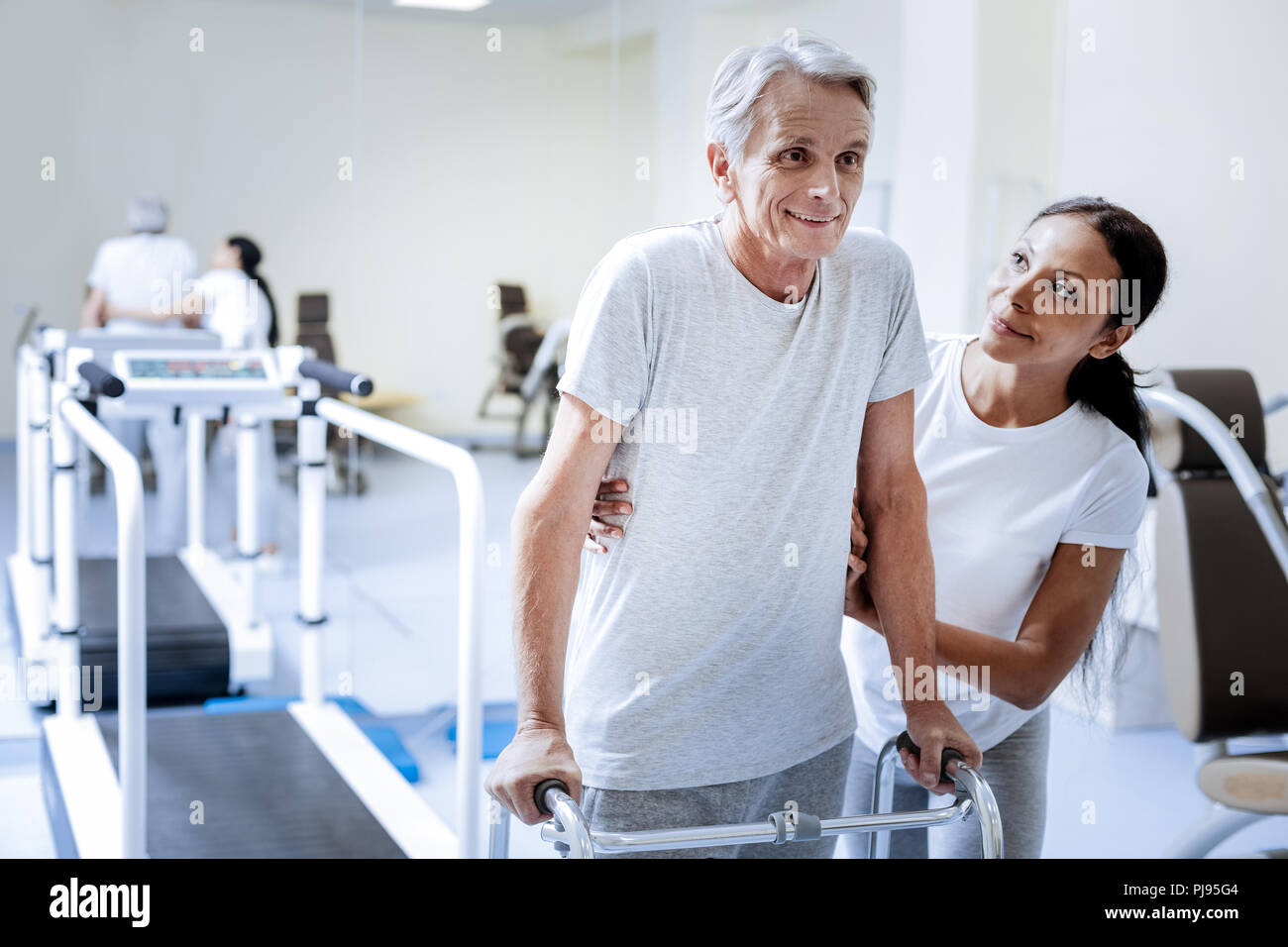 Fröhliche pensionierter Mann Fortschritte, während er in einem Rehabilitationszentrum Stockfoto