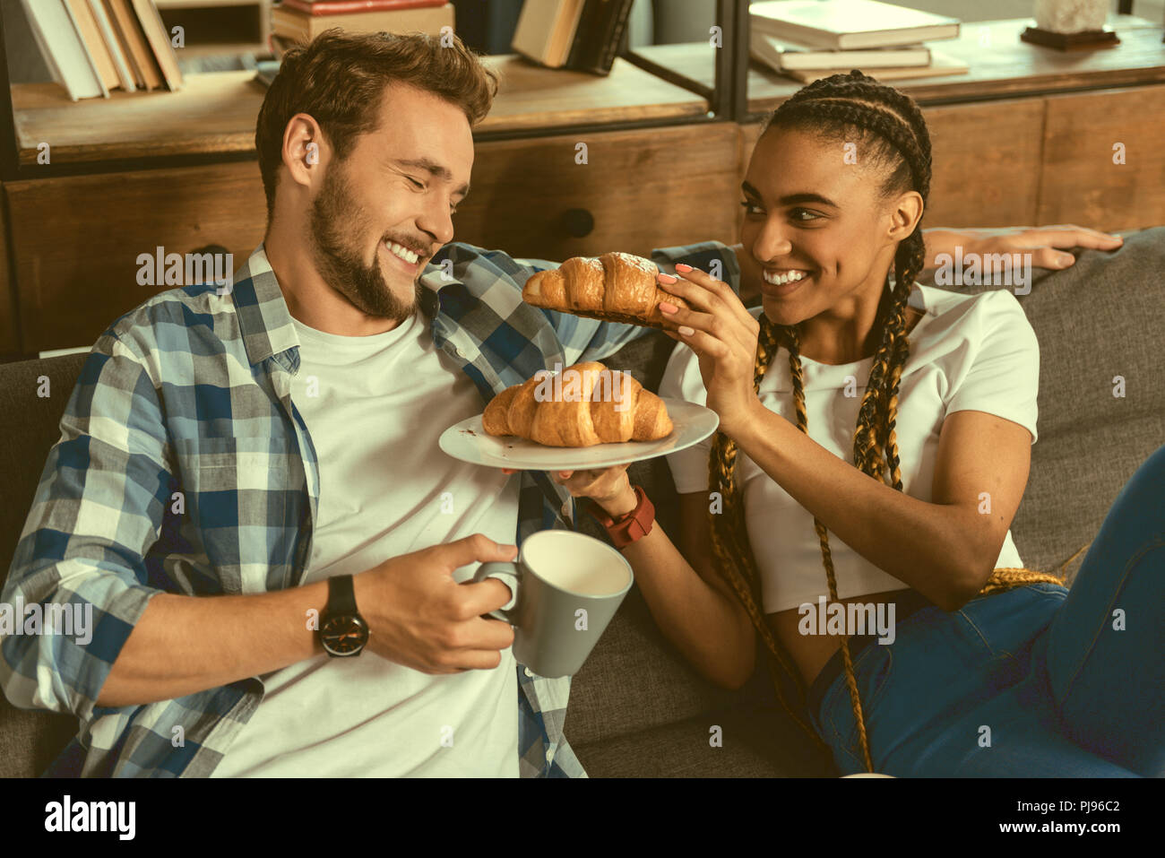 Liebevolle Mädchen behandeln Freund croissant Stockfoto