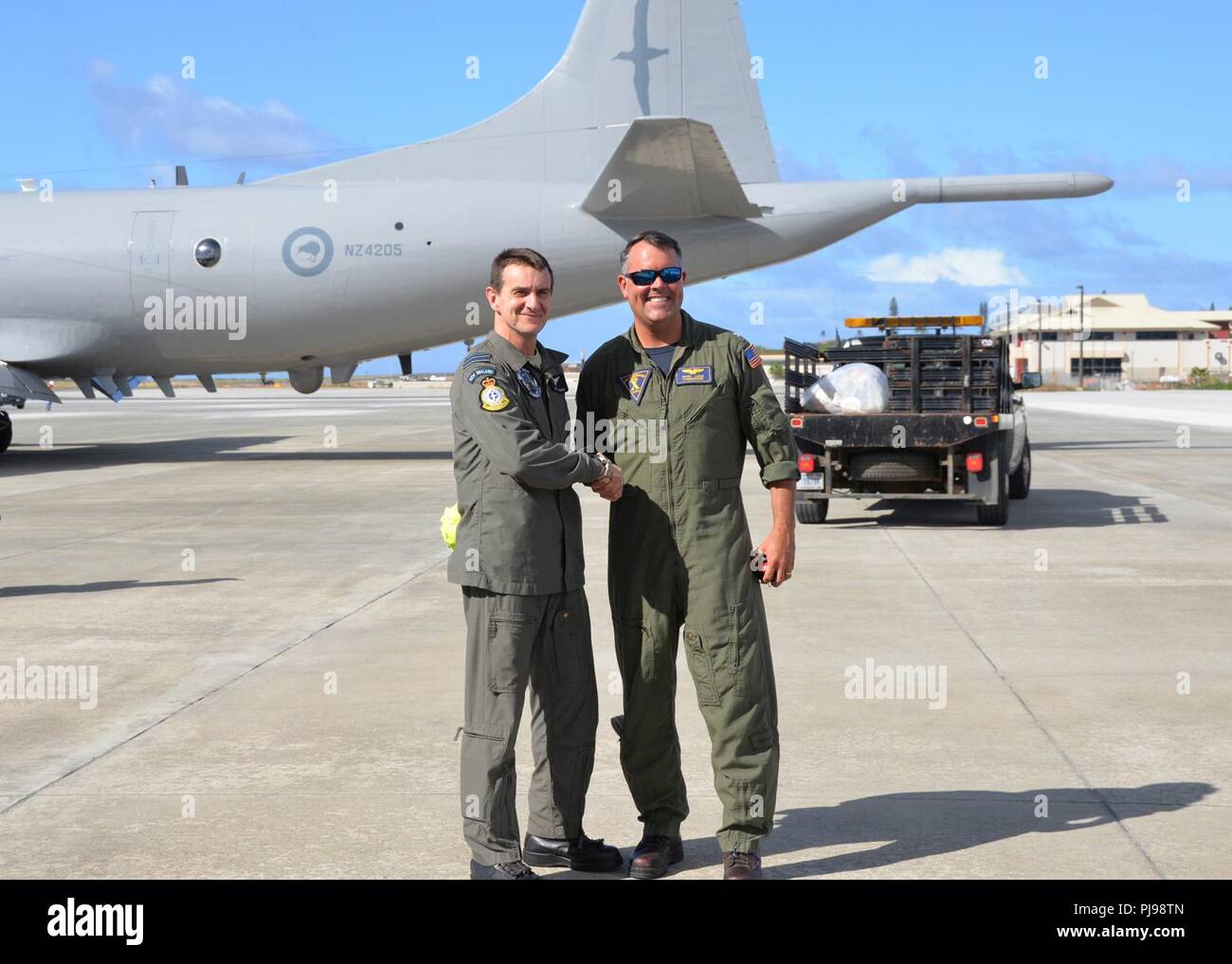 CORPS BASE HAWAII, Hawaii (5. Juli 2018) - Kapitän Kevin Lang, Commander Task Force 172, grüßt Flügel Cmdr. Aaron Junge, Commander, Task Unit 172.1.3 kurz nach der Ankunft der Royal New Zealand Air Force Nr. 5 Staffel P-3K2 Orion auf der Marine Corps Base Hawaii für Rim der Pazifik (Rimpac) Übung, 5. Juli. 25 Nationen, mehr als 46 Schiffe und 5 U-Boote, über 200 Flugzeuge, und 25.000 Mitarbeiter beteiligen sich an Rimpac vom 27. Juni bis 2. August in und um die hawaiischen Inseln und Südkalifornien. Die weltweit größte internationale maritime Übung RIMPAC bietet eine einzigartige Stockfoto