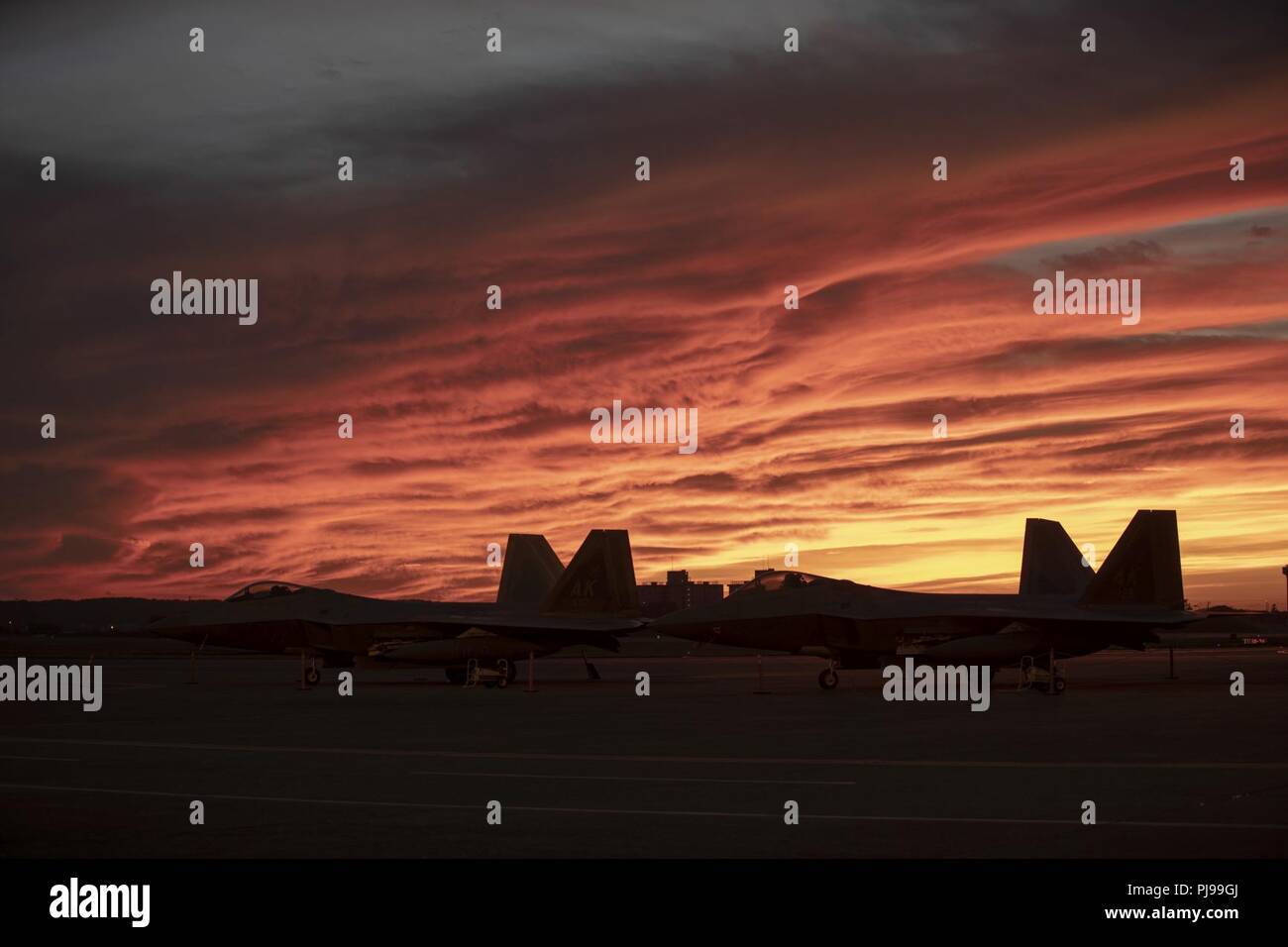 Zwei U.S. Air Force F-22 Raptors aus Joint Base Elmendorf-Richardson, Alaska, sitzen auf der Flightline, 8. Juli 2018, bei Yokota Air Base, Japan. Acht F-22 s von Kadena Air Base, Japan wegen Taifun Maria evakuiert. Die F-22 wird unter Theater Sicherheitspaket US-FIRMA PACOM (TSP) Programm, das im Betrieb seit 2004 eingesetzt. Stockfoto