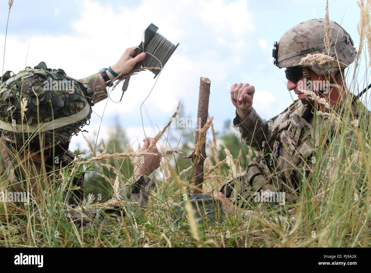 U.S. Army Staff Sgt. Robert Moore (rechts), auf das erste Geschwader zugewiesen sind, 2.Kavallerie Regiments, hilft bei der britischen Armee LT. Tom Chapman (links), 1. die Queen's Dragoon Guards zugewiesen, bis M18 A1 Claymore Mine während eines multinationalen claymore Ausbildung Übung mit Battle Group Polen Bemowo Piskie, Polen am 10. Juli 2018 eingestellt. Battle Group Polen ist ein einzigartiges, multinationale Koalition von USA, Großbritannien, Kroatischen und rumänischen Soldaten, die mit der polnischen 15 mechanisierte Brigade als Abschreckung Kraft zur Unterstützung des NATO-Enhanced vorwärts Präsenz dienen. Stockfoto