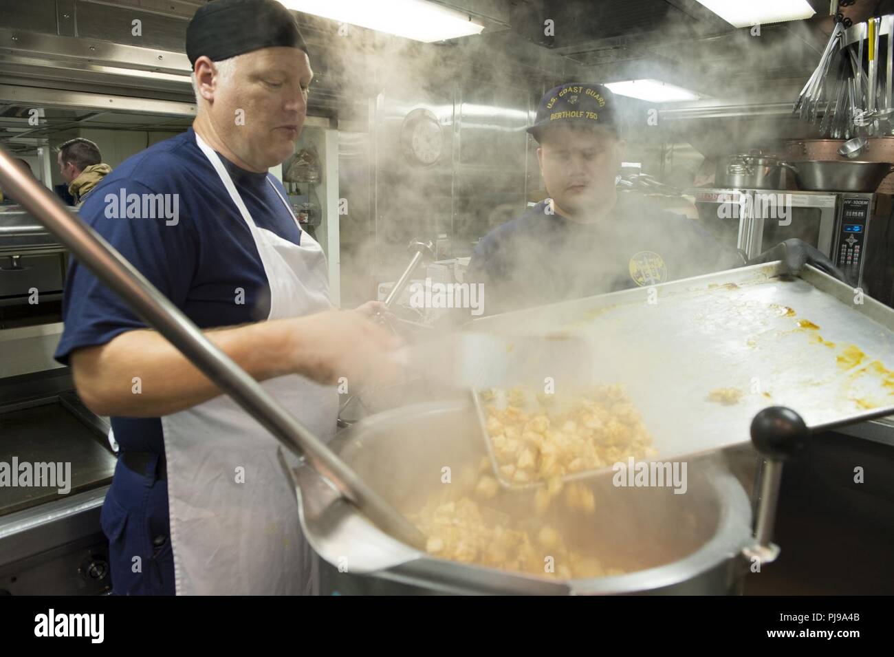 JOINT BASE Pearl Harbor - HICKAM, Hawaii (9. Juli 2018) Petty Officer 1st Class Allen Martin und Petty Officer 2. Klasse Michael Gabanyic bereiten das Mittagessen an Bord der USCGC Bertholf (WMSL 750) Juli 9, 2018, während in Pearl Harbor festgemacht, in der Unterstützung von Rimpac 2018. 25 Nationen, mehr als 46 Schiffe und 5 U-Boote, über 200 Flugzeuge und 25.000 Angestellte beteiligen sich an Rimpac vom 27. Juni bis 2. August in und um die Hawaiianische Insel und Südkalifornien. Die weltweit größte internationale maritime Übung RIMPAC bietet eine einzigartige Ausbildung während der Förderung und Erhaltung der Co Stockfoto