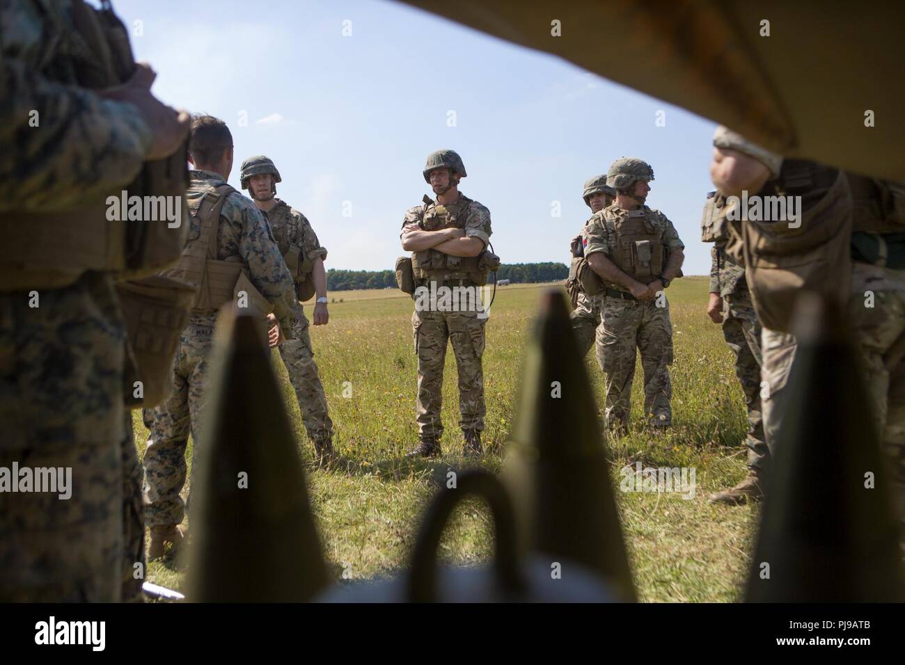 Britische service Mitglieder interagieren mit US-Marines mit Echo. Akku, 2. Bataillon, 10 Marine Regiment (2/10), 2nd Marine Division, in Salisbury, England, Juli 5, 2018. Marines mit der Unit durchgeführt live-fire Übungen mithilfe der M777 Haubitze während der Übung grüne Kanone 18. Grüne Kanone ist eine multinationale Übung mit US-Marines die Möglichkeit, Taktiken und Techniken sowie Stärkung der Beziehungen zwischen den Alliierten und Partner Nationen. Stockfoto