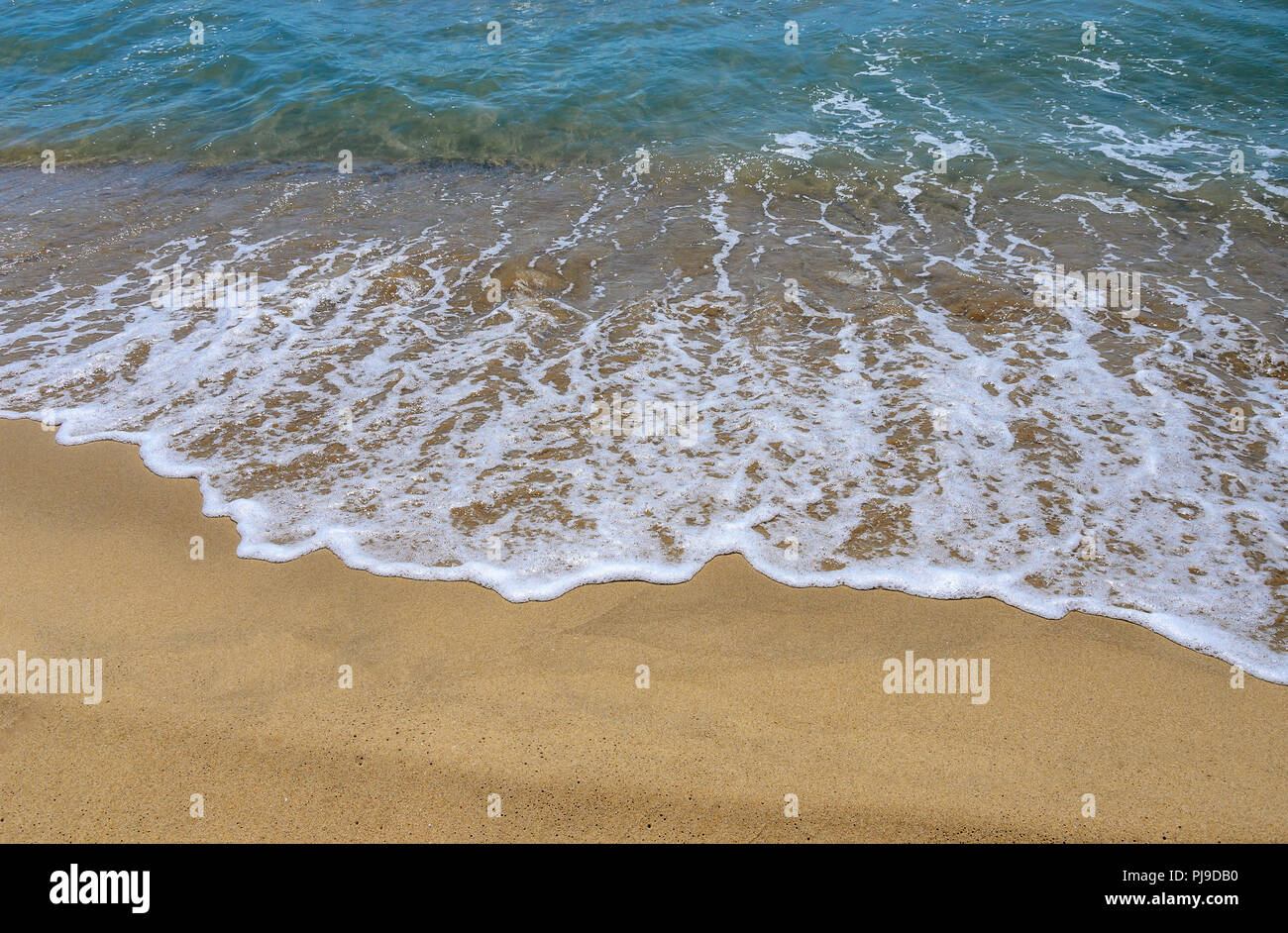 Nasser Sand am Strand. Ein Teil des Meeres ist sichtbar. Stockfoto
