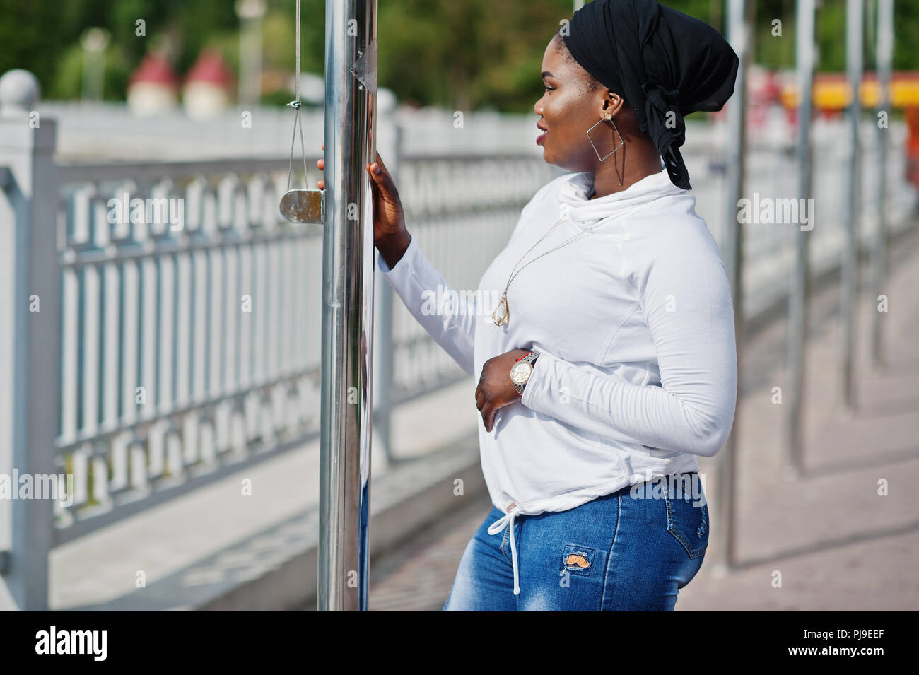 African Muslim Mädchen in Schwarz hijab, weißen Pulli und Jeans, Outdoor. Stockfoto