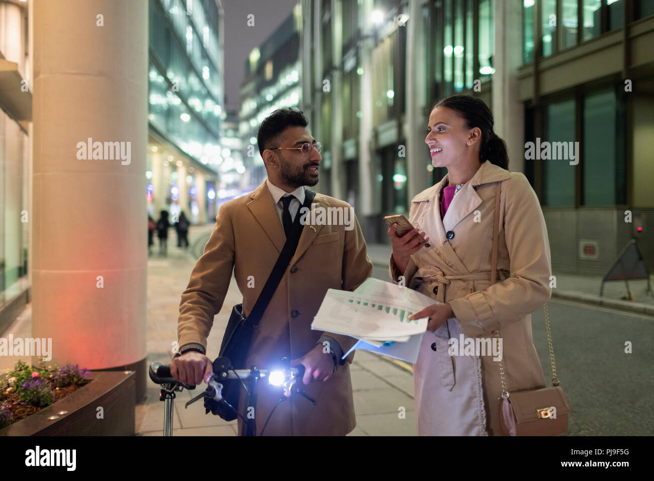 Geschäft Leute diskutieren Papierkram auf städtischen Gehsteig in der Nacht Stockfoto