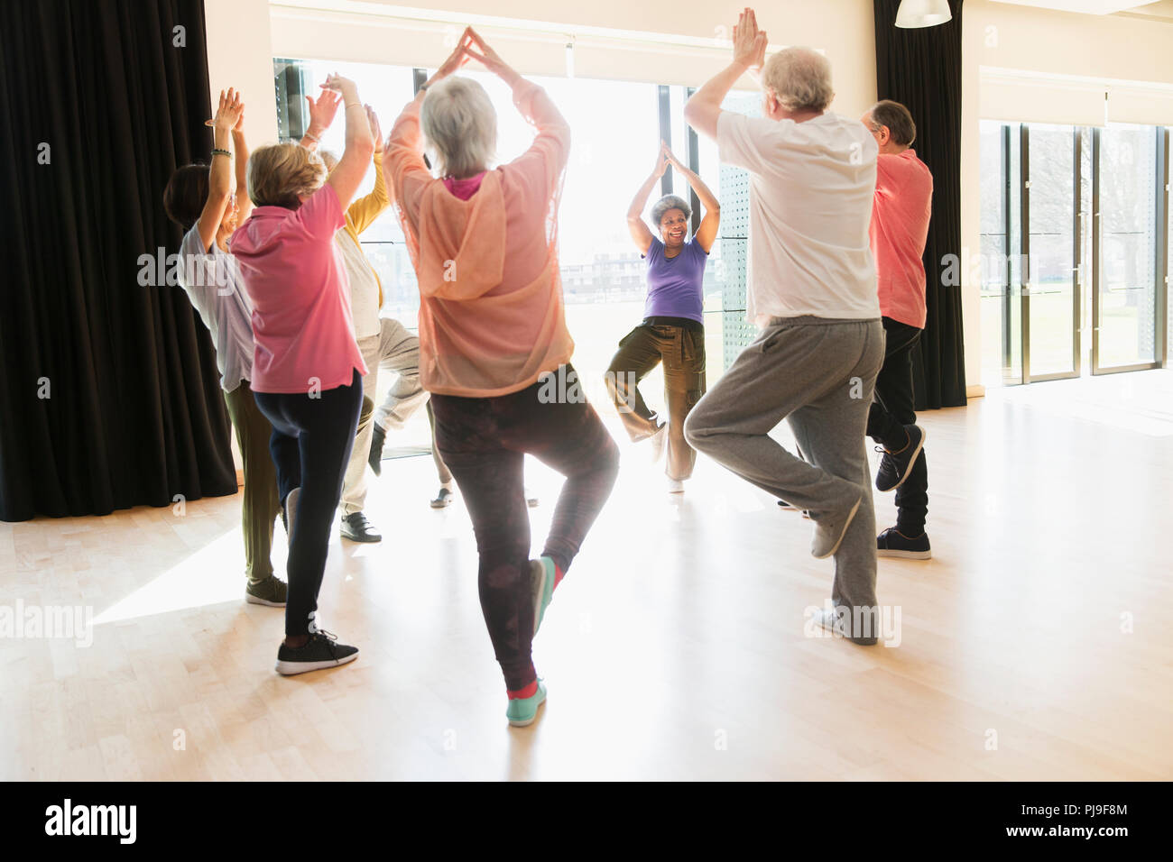 Aktive Senioren trainieren, Yoga die Baumhaltung im Kreis Stockfoto