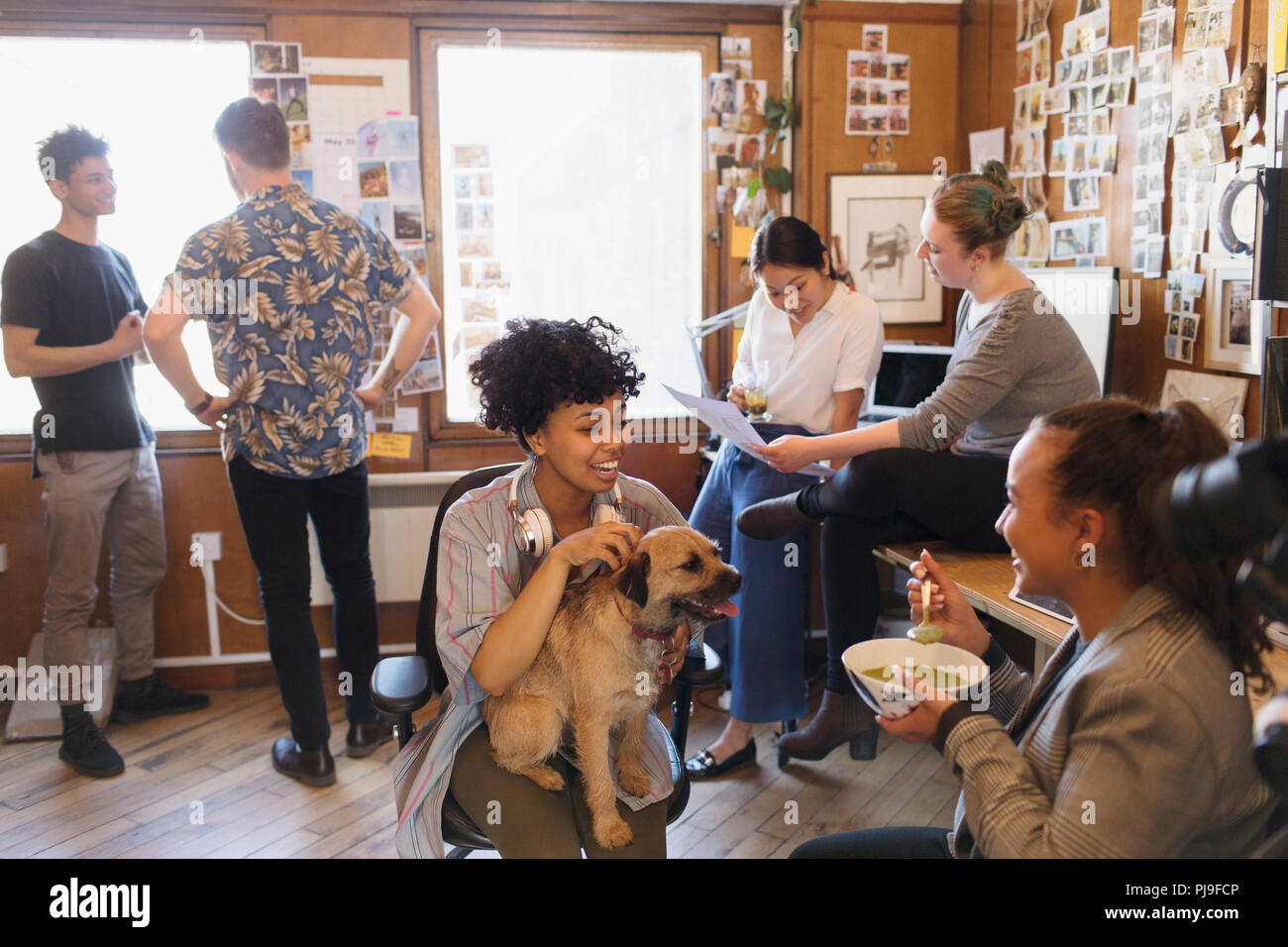 Creative Business Leute mit Hund arbeiten und essen im Büro Stockfoto