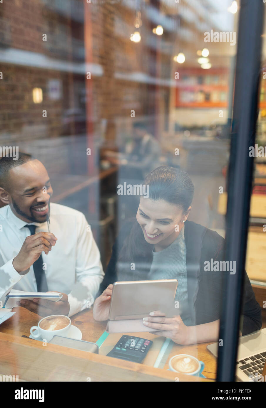 Lächelnd Geschäftsleute mit digitalen Tablet, Arbeiten im Cafe Fenster Stockfoto
