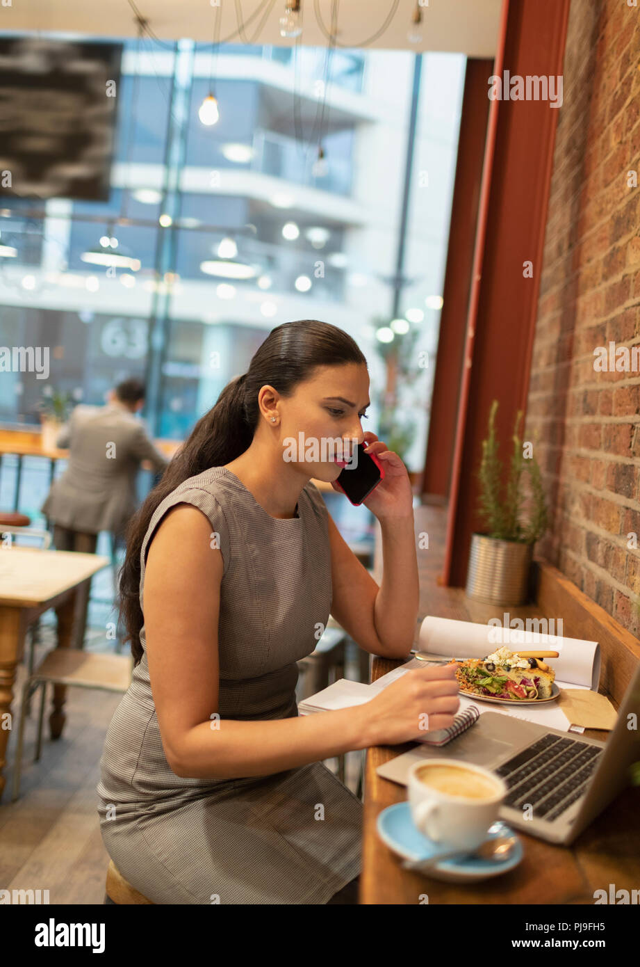 Geschäftsfrau mit Smart Phone, am Laptop arbeiten im Cafe Stockfoto