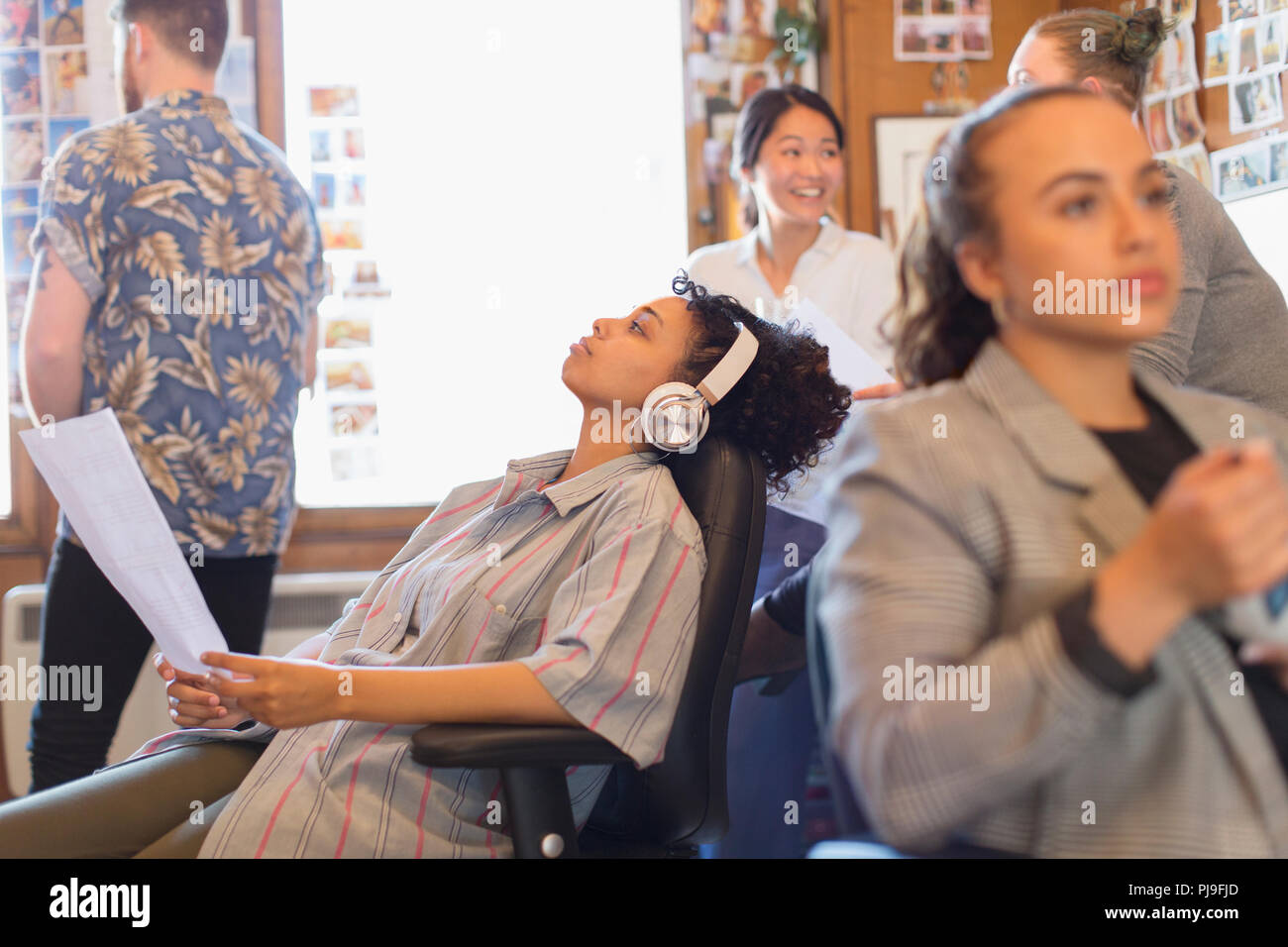 Kreative Geschäftsfrau mit Kopfhörern Musik hören im Büro Stockfoto