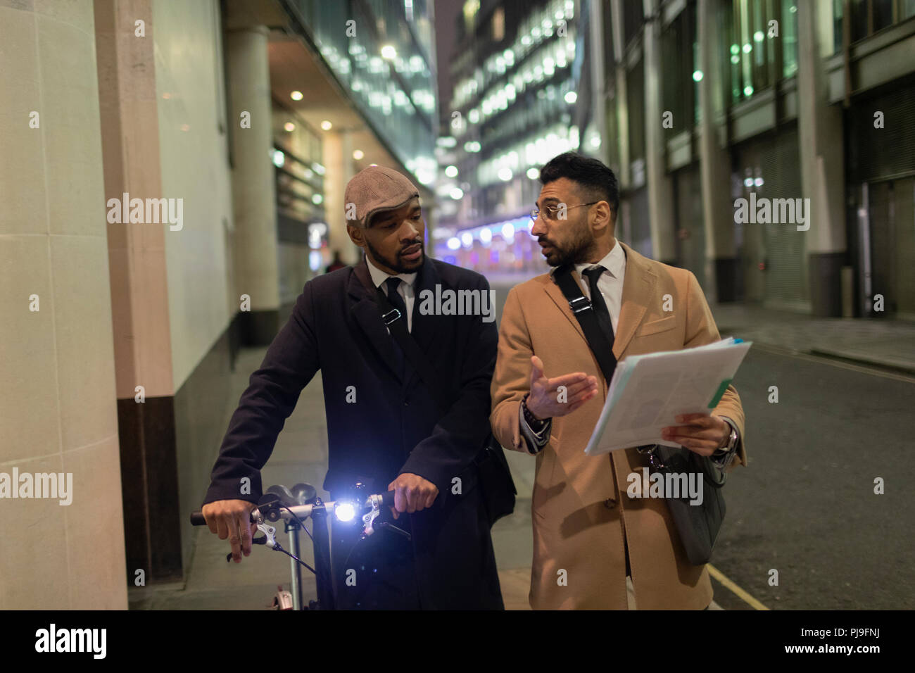 Geschäftsleute mit Fahrrad und Schreibarbeit zu Fuß auf städtischen Bürgersteig Stockfoto