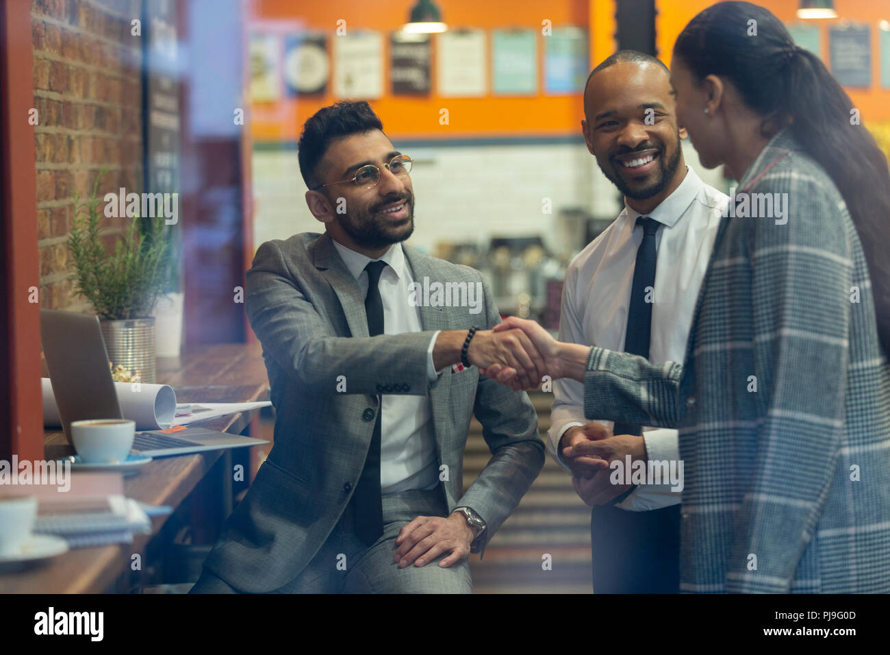 Geschäftsleute handshaking im Cafe Stockfoto