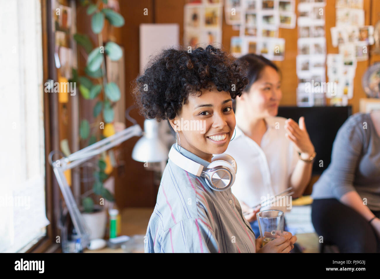 Porträt Lächeln, selbstbewussten kreativen Geschäftsfrau mit Kopfhörer im Büro Stockfoto
