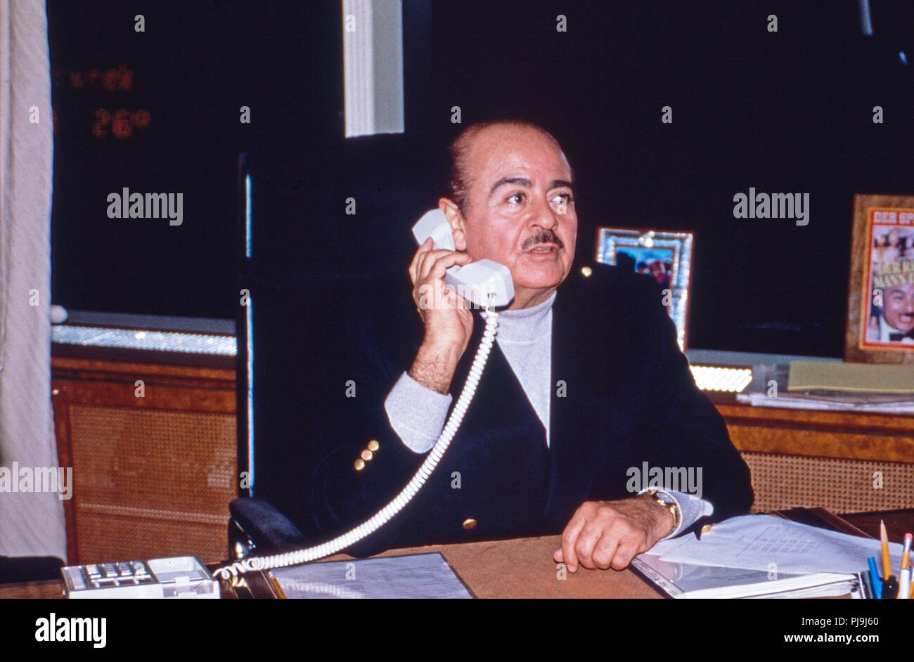 Geschäftsmann Adnan Kashoggi eine seinem Schreibtisch im Büro im Olympic Tower in New York, USA 1986. Kaufmann Adnan Khashoggi an seinem Schreibtisch in seinem Büro bei Olympic Tower in New York, USA 1986. Stockfoto