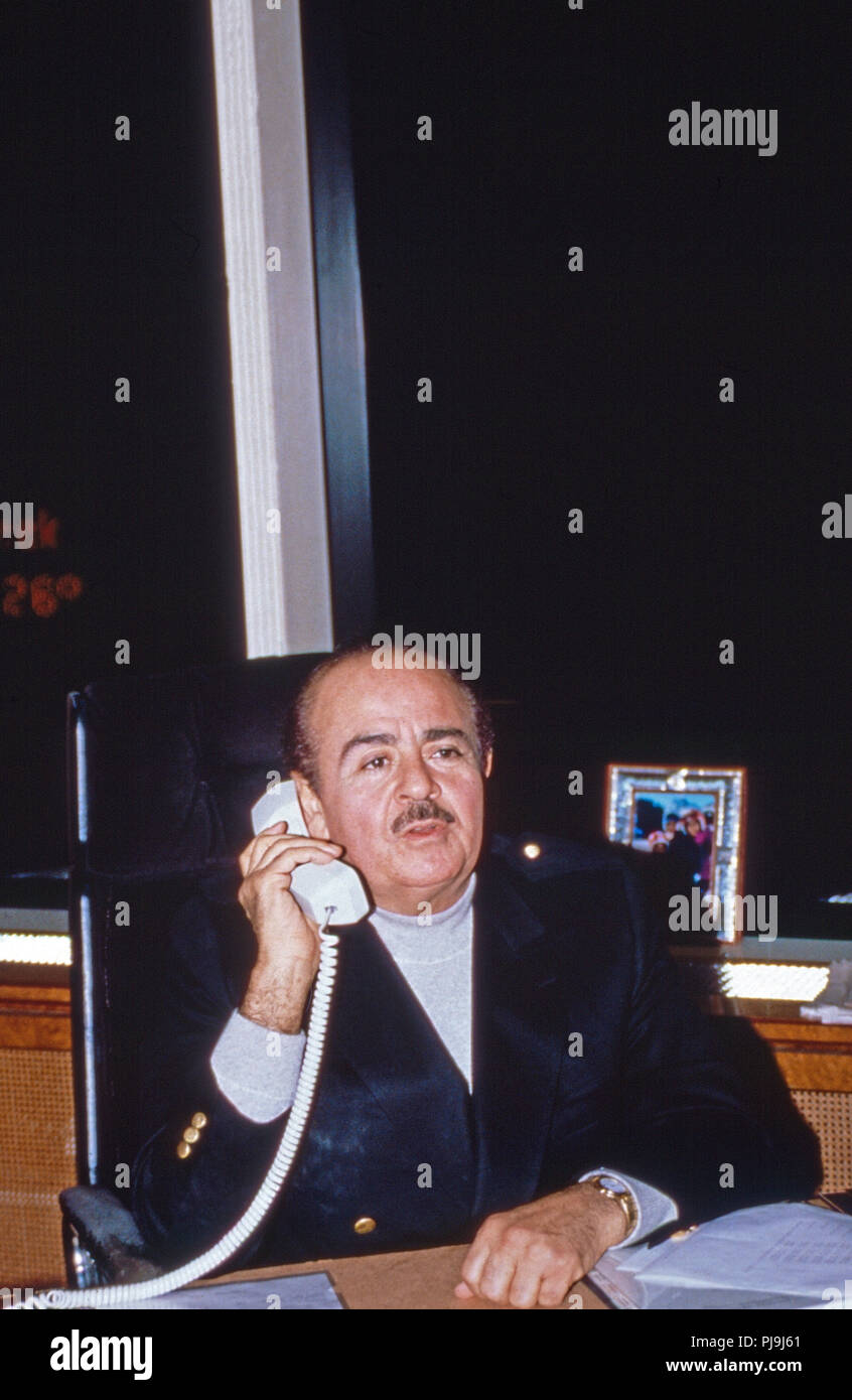 Geschäftsmann Adnan Kashoggi eine seinem Schreibtisch im Büro im Olympic Tower in New York, USA 1986. Kaufmann Adnan Khashoggi an seinem Schreibtisch in seinem Büro bei Olympic Tower in New York, USA 1986. Stockfoto