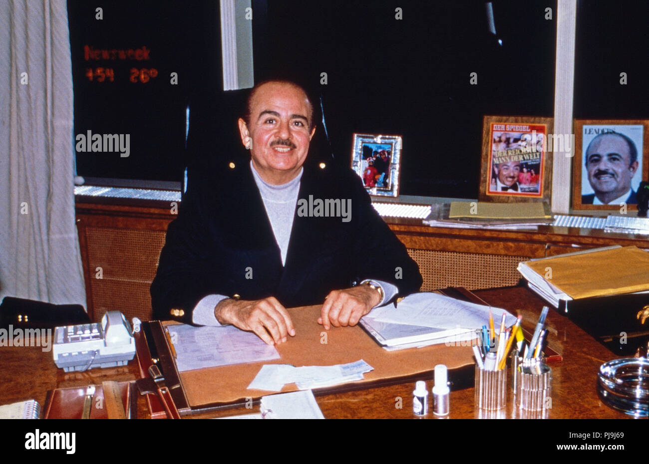 Geschäftsmann Adnan Kashoggi eine seinem Schreibtisch im Büro im Olympic Tower in New York, USA 1986. Kaufmann Adnan Khashoggi an seinem Schreibtisch in seinem Büro bei Olympic Tower in New York, USA 1986. Stockfoto