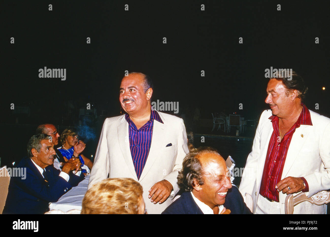 Adnan Kashoggi (2. v. l.) bei einer Abendveranstaltung mit Alfonso Prinz von Hohenlohe Langenburg in Marbella, Spanien 1985. Adnan Khashoggi (2. links) bei einer Abendveranstaltung mit Alfonso Prinz von Hohenlohe Langenburg in Marbella, Spanien 1985. Stockfoto
