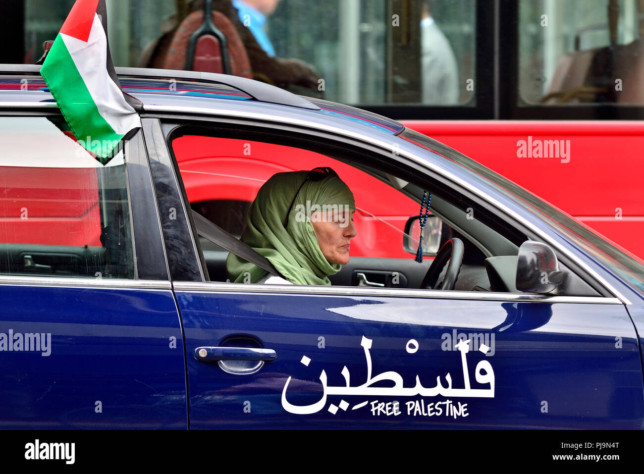 Frau mit Kopftuch ein Auto mit einem palästinensischen Flagge und "Freie Palästina" auf der Tür gedruckt, Central London, England, UK. 2018 Stockfoto