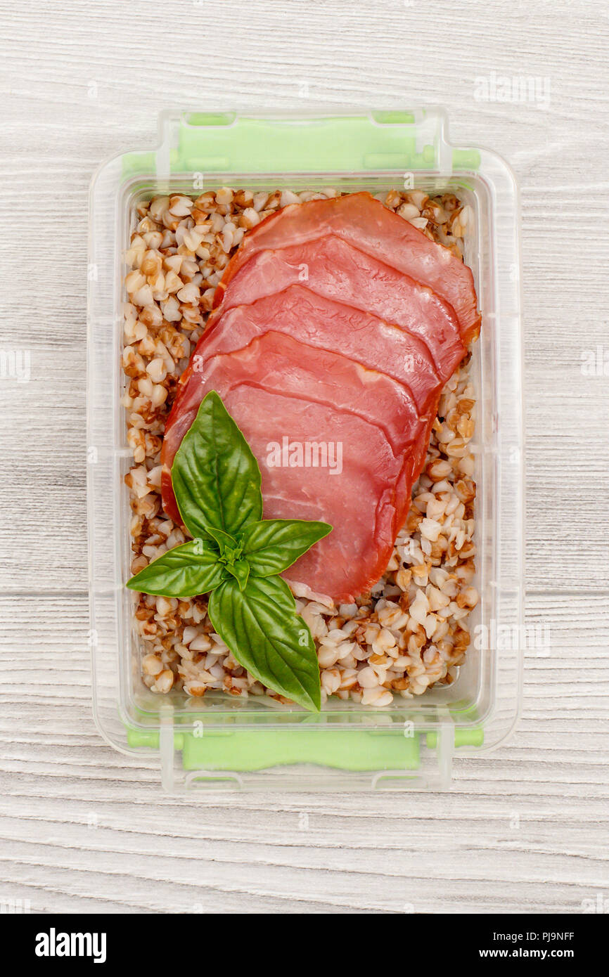Kunststoff Mahlzeit prep Container mit gekochten Buchweizen Brei und Scheiben von Fleisch. Ansicht von oben Stockfoto