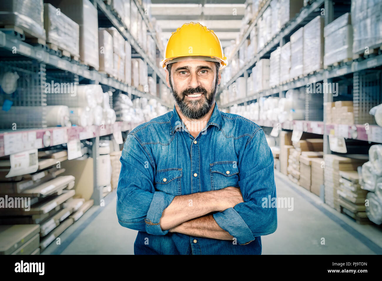 Portrait des Arbeitnehmers verschränkte Arme im Lager Stockfoto