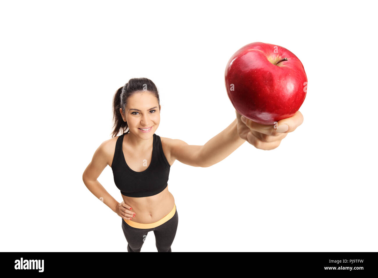 Junge weibliche in Sportkleidung mit einem roten Apfel auf weißem Hintergrund Stockfoto