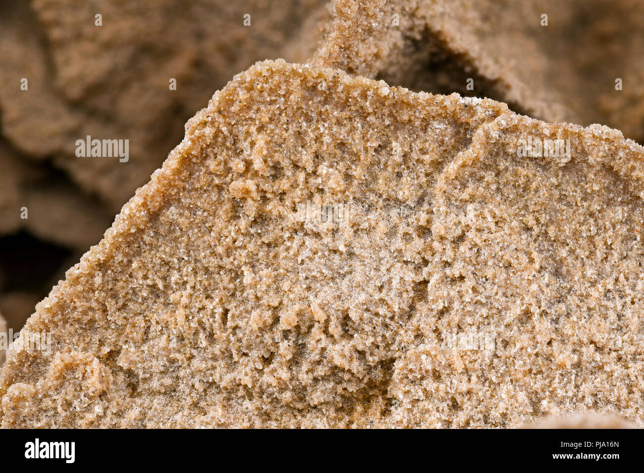 Rosafarbener Sand stieg aus nächster Nähe auf, Details der Sandkörner und die einzigartige Struktur einer Wüstensandrose. Stockfoto