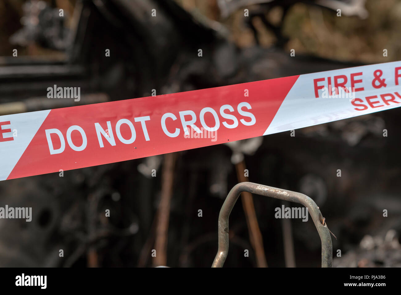 Brand beschädigt Auto zeigt die Fire & Rescue Service Nicht kreuzen Kunststoffband. Stockfoto