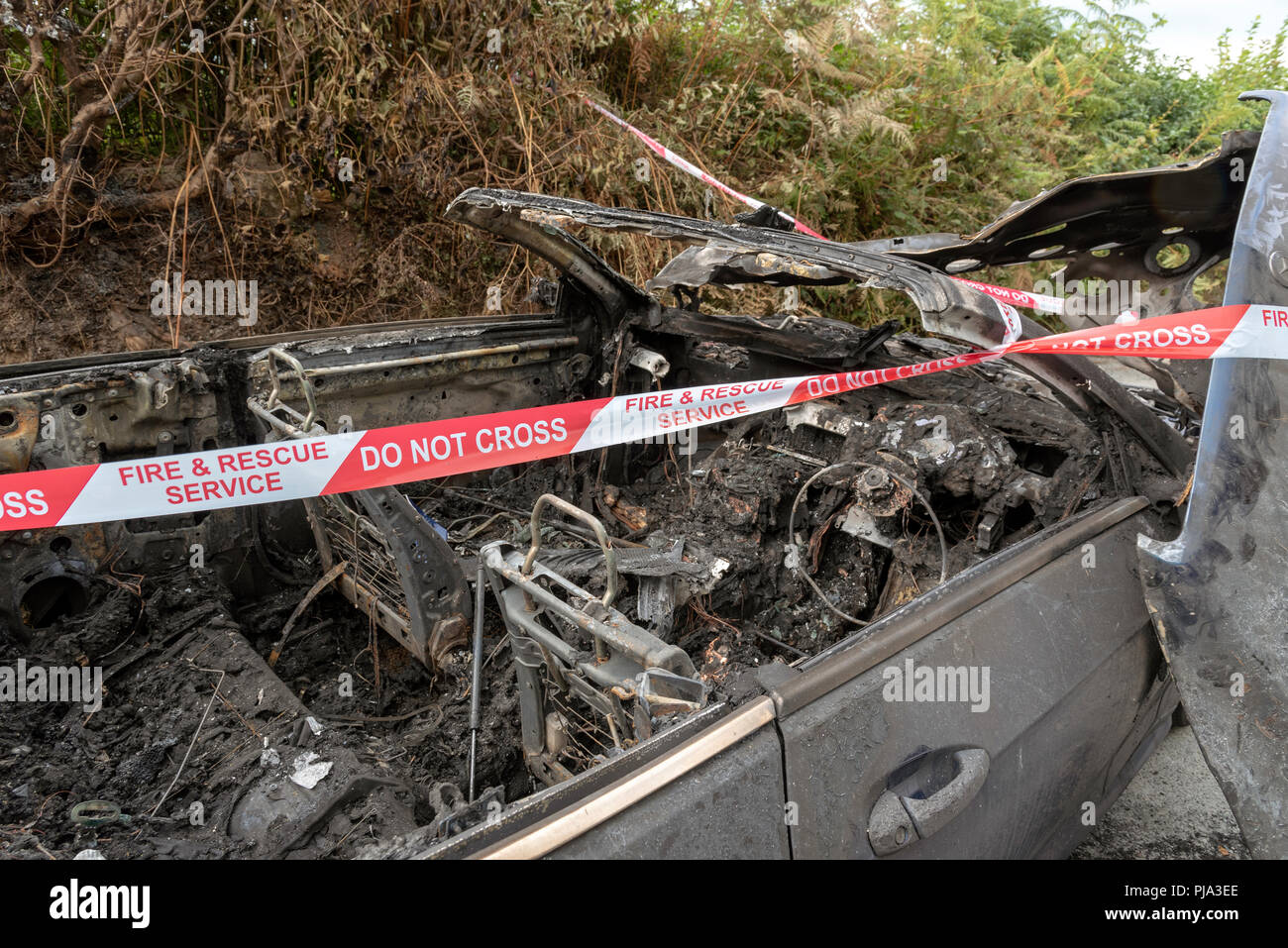 Brand beschädigt Auto zeigt die Fire & Rescue Service Nicht kreuzen Kunststoffband. Stockfoto