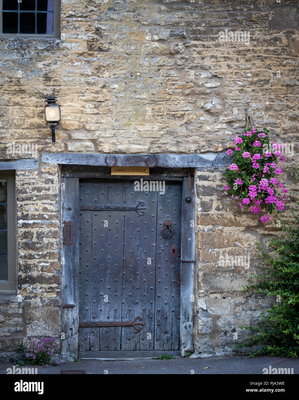 Eingangstür zum Haus entlang Hautpstraße, Castle Combe, Wiltshire, England Stockfoto