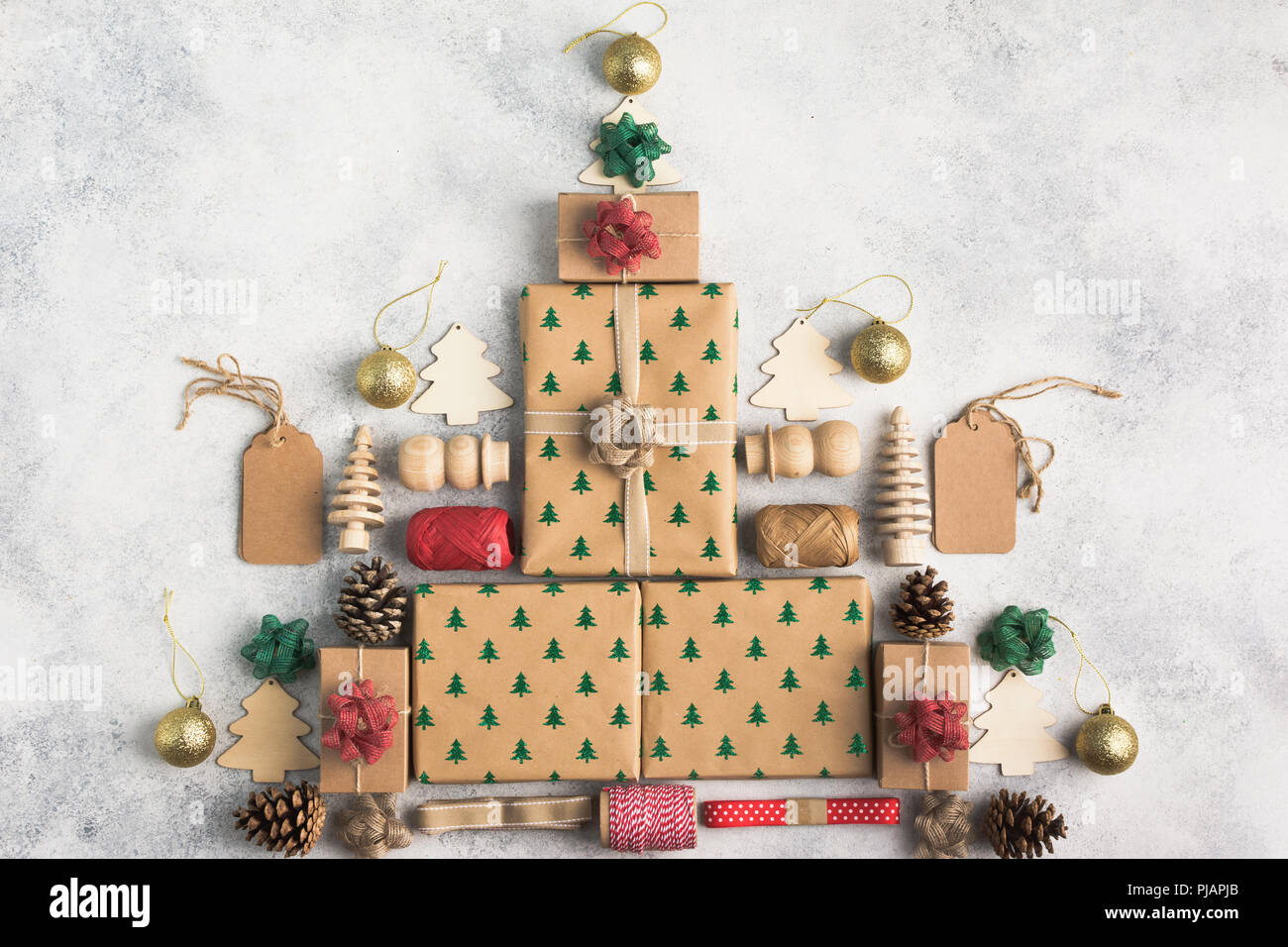 Weihnachten Konzept, Weihnachtsbaum aus brauner Zeit Boxen, roten und grünen Bögen, Tannenzapfen, Jute Garn, Holz- Verzierungen auf den hellen Hintergrund, t Stockfoto