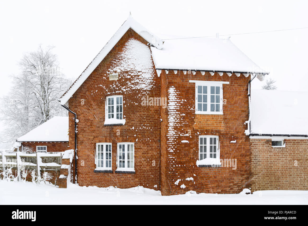 Altes viktorianisches Haus mit Dach und Wände aus Backstein im Schnee im Winter Stockfoto
